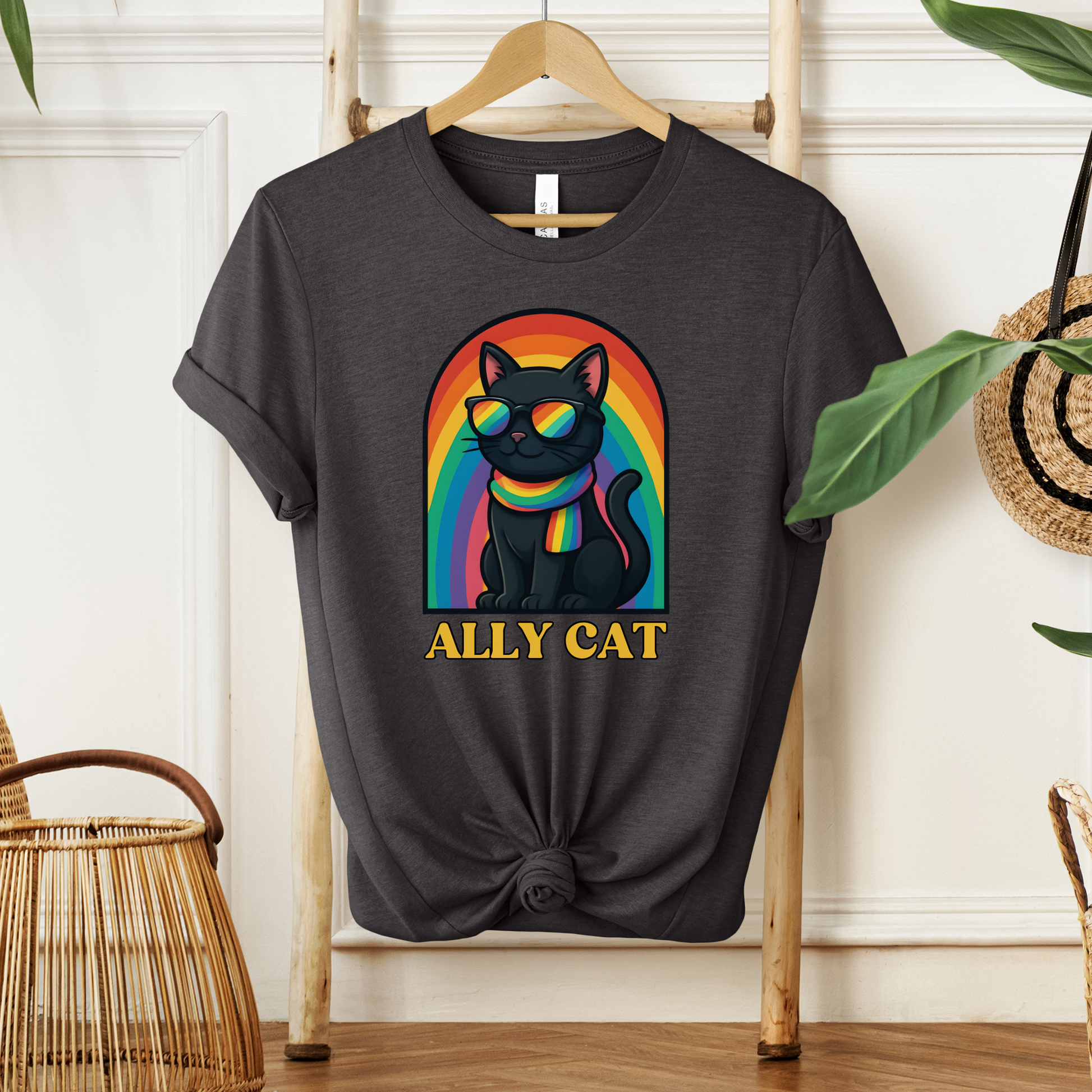 Black t-shirt with a colorful cat graphic and 'ALLY CAT' text on a wooden hanger. ally cat shirt, rainbow cat shirt, LGBTQ ally shirt, pride cat tee, allyship shirt, cat lover shirt, unisex graphic tee, rainbow shirt, pride apparel, support LGBTQ, fun ally tee, colorful cat shirt, statement tee, cat graphic shirt, inclusive clothing