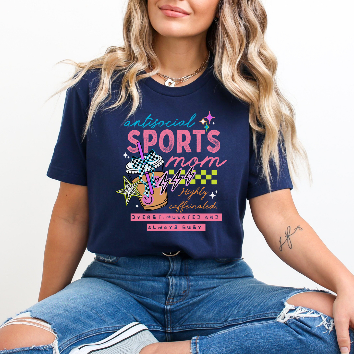 Antisocial Sports Mom Highly Caffeinated Overstimulated And Always Busy shirt with colorful sporty graphic on a unisex tee. antisocial sports mom, sports mom shirt, funny mom tee, caffeinated mom shirt, busy mom apparel, unisex graphic tee, overstimulated mom shirt, sideline mom shirt, coffee mom shirt, statement tee, mom life shirt, everyday casual tee, gift for sports mom, humorous mom shirt, colorful graphic tee