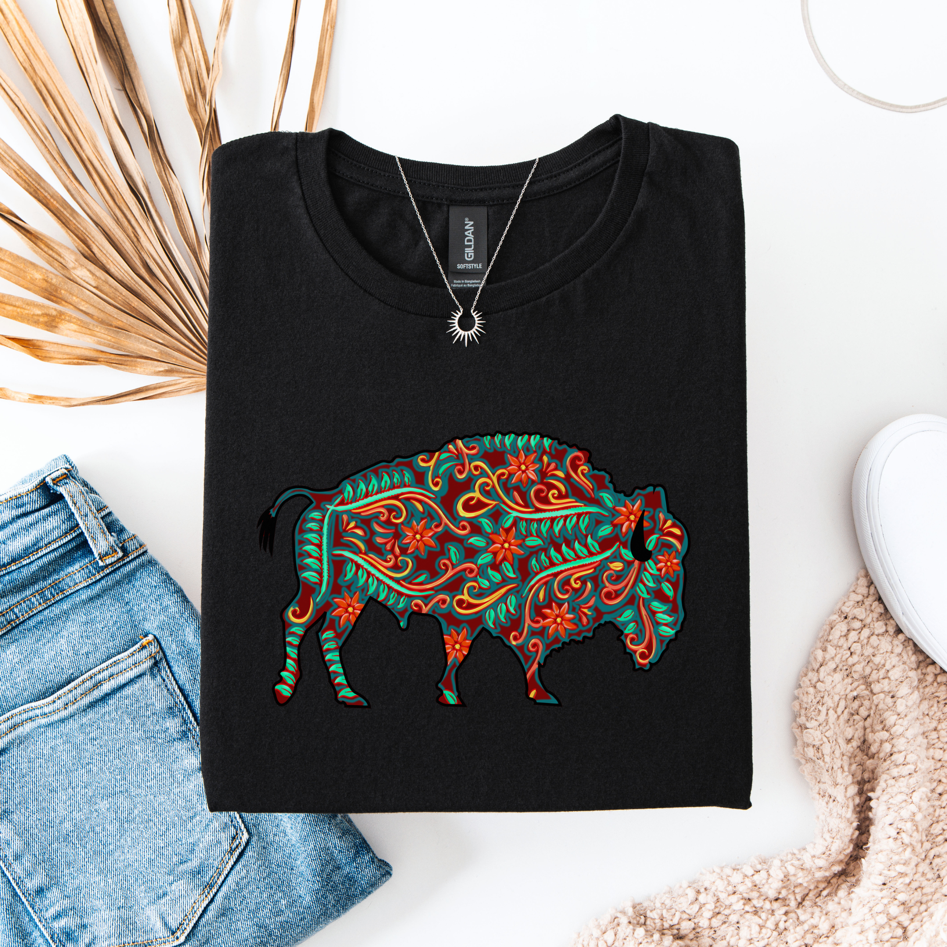 Black t-shirt with colorful bull design on a white surface with jeans and a hat. native floral buffalo shirt, indigenous buffalo shirt, floral buffalo tee, indigenous design shirt, buffalo graphic tee, native inspired apparel, cultural pride shirt, unisex indigenous tee, floral indigenous shirt, buffalo and floral shirt, indigenous owned clothing, meaningful graphic tee