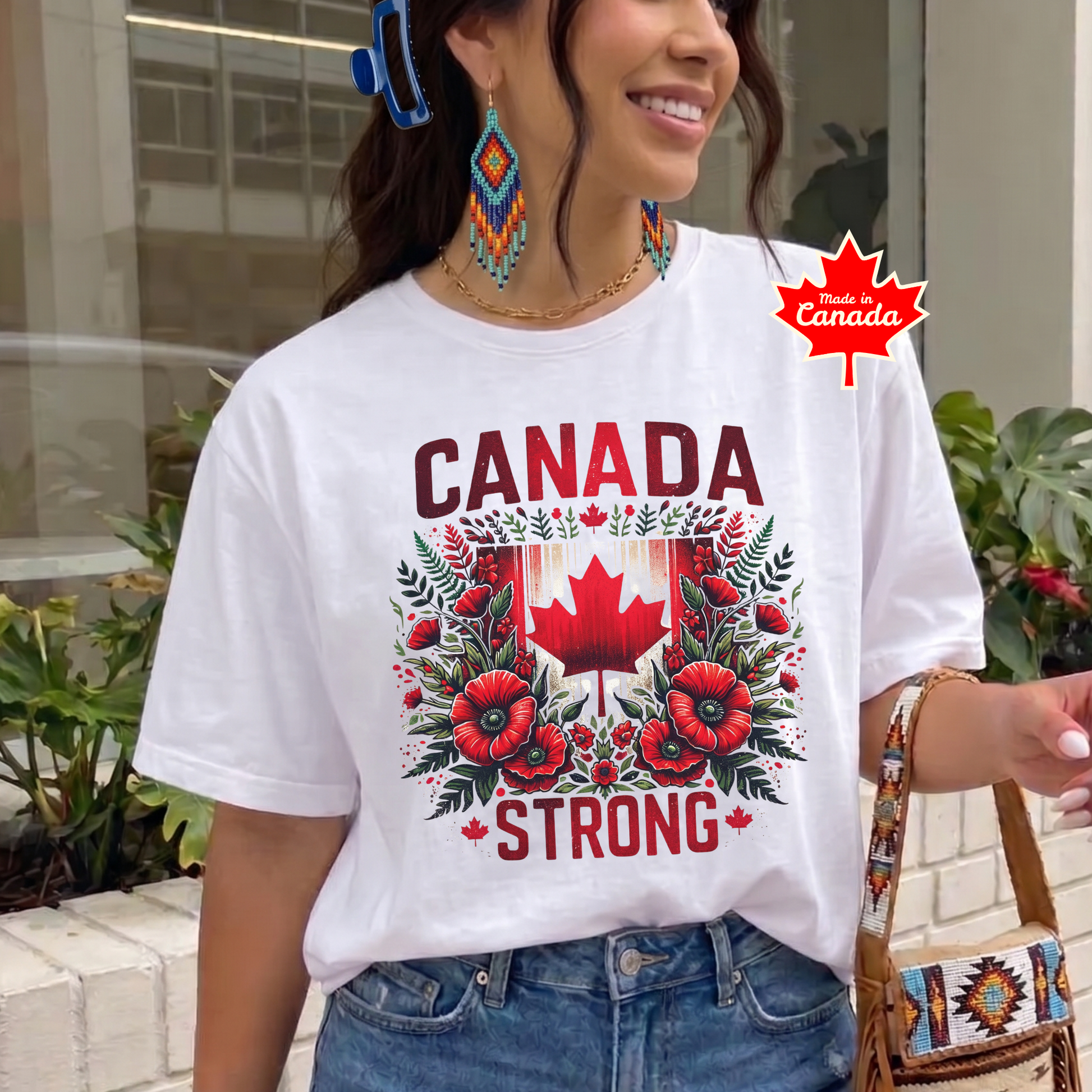 Canada Strong shirt featuring a red Canadian maple leaf surrounded by vibrant red flowers and greenery with bold Canada Strong text. Proudly made in Canada, this patriotic floral graphic tee celebrates Canadian pride, resilience, and unity.