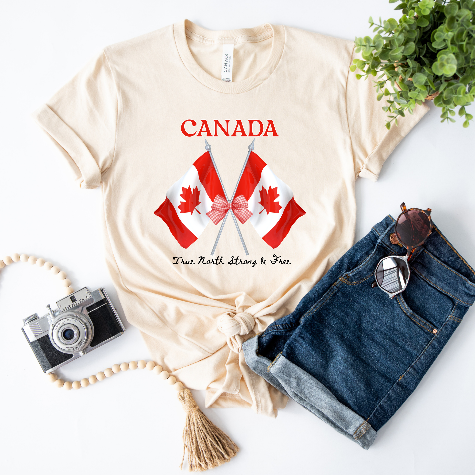 Canada Day Flag Coquette Bow True North Strong and Free Shirt featuring two Canadian flags with a red gingham bow and patriotic Canadian design. canada day shirt, canada shirt, canadian pride shirt, true north strong and free, coquette bow shirt, canada flag shirt, patriotic canada shirt, canada day outfit, canada day apparel, gingham bow shirt, july 1st shirt, canadian clothing, red bow shirt, canada celebration shirt, canadian gift, cute canada shirt, canada day tee, canada flag bow, canada coquette shirt