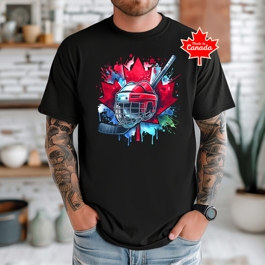 Canada Hockey Shirt featuring a colorful hockey helmet and stick graphic layered over a vibrant red Canadian maple leaf with paint splash accents. Proudly made in Canada, this patriotic hockey t-shirt is perfect for hockey fans, players, coaches, and Canada Day celebrations.