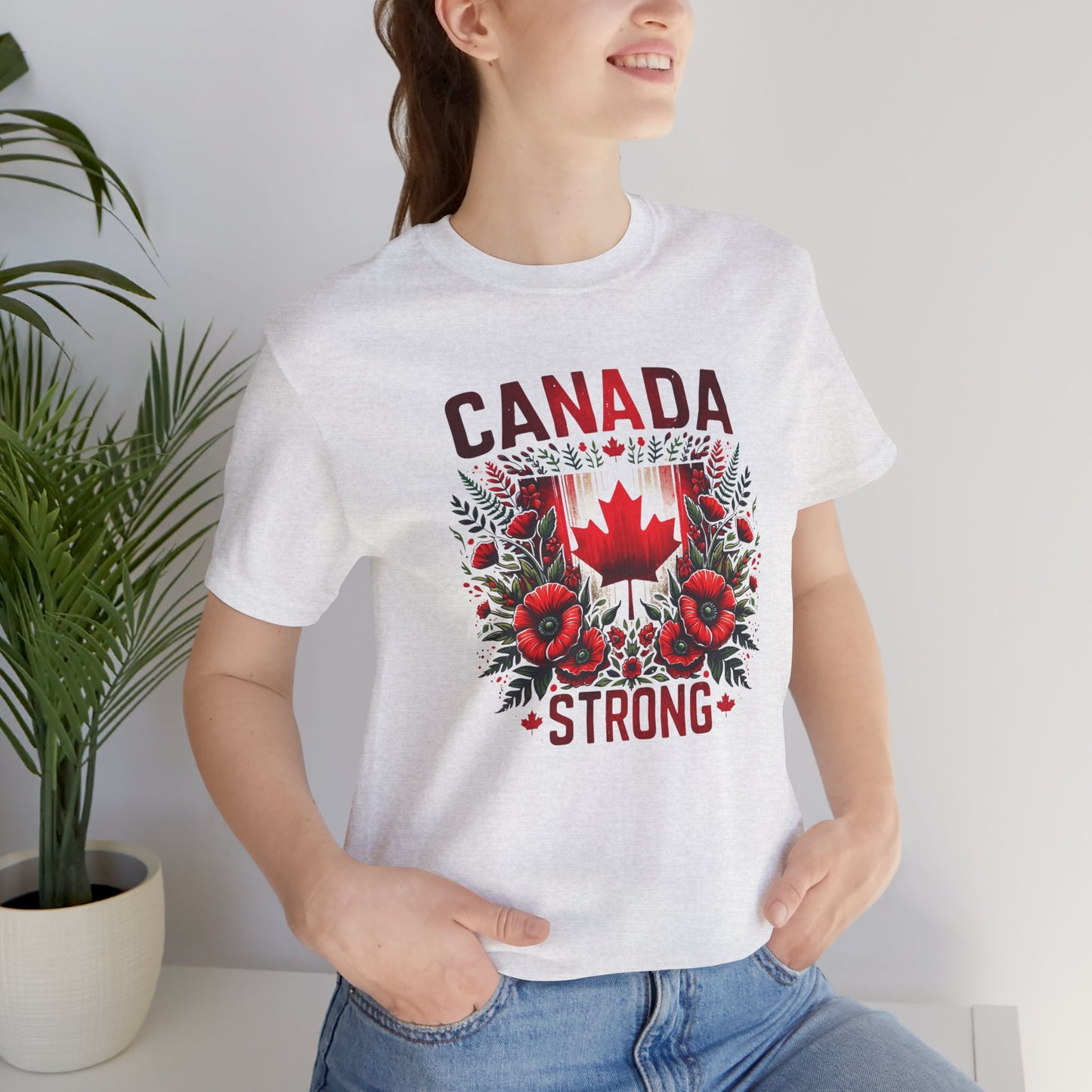 Canada Strong shirt featuring a red Canadian maple leaf surrounded by vibrant red flowers and greenery with bold Canada Strong text. Proudly made in Canada, this patriotic floral graphic tee celebrates Canadian pride, resilience, and unity.