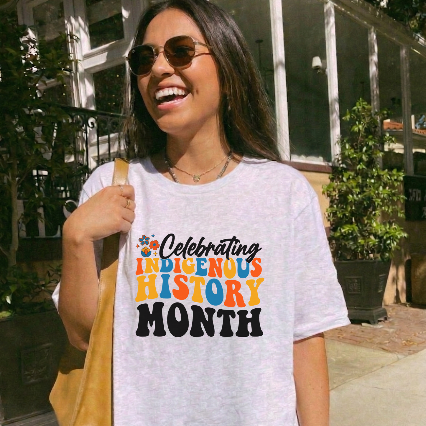 Celebrating Indigenous History Month shirt with colorful text and hand-drawn floral design on a unisex t-shirt. celebrating indigenous history month, indigenous history month shirt, hand drawn florals, sahdeh spruce design, indigenous pride tee, cultural celebration shirt, unisex graphic tee, indigenous apparel, native pride shirt, heritage clothing, meaningful statement tee, everyday wear shirt, community event shirt, indigenous month shirt, floral graphic tee