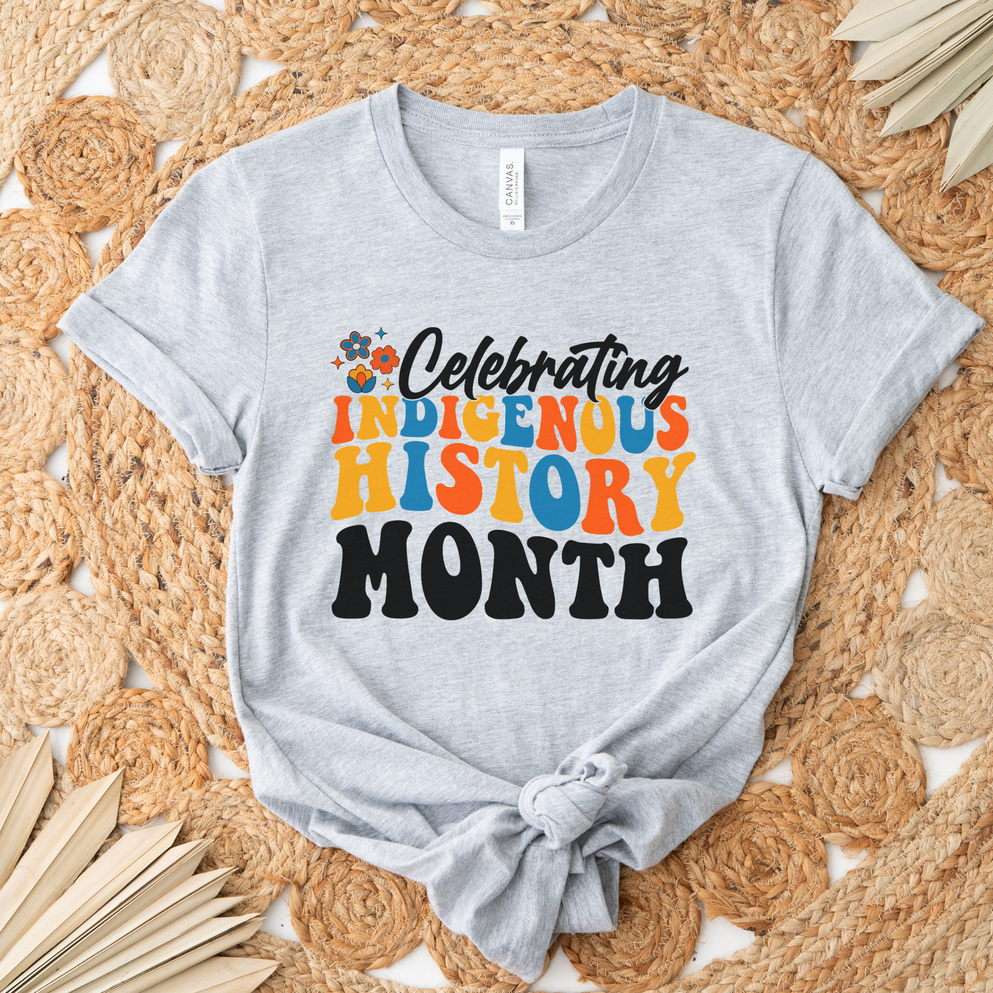 Celebrating Indigenous History Month shirt with colorful text and hand-drawn floral design on a unisex t-shirt. celebrating indigenous history month, indigenous history month shirt, hand drawn florals, sahdeh spruce design, indigenous pride tee, cultural celebration shirt, unisex graphic tee, indigenous apparel, native pride shirt, heritage clothing, meaningful statement tee, everyday wear shirt, community event shirt, indigenous month shirt, floral graphic tee