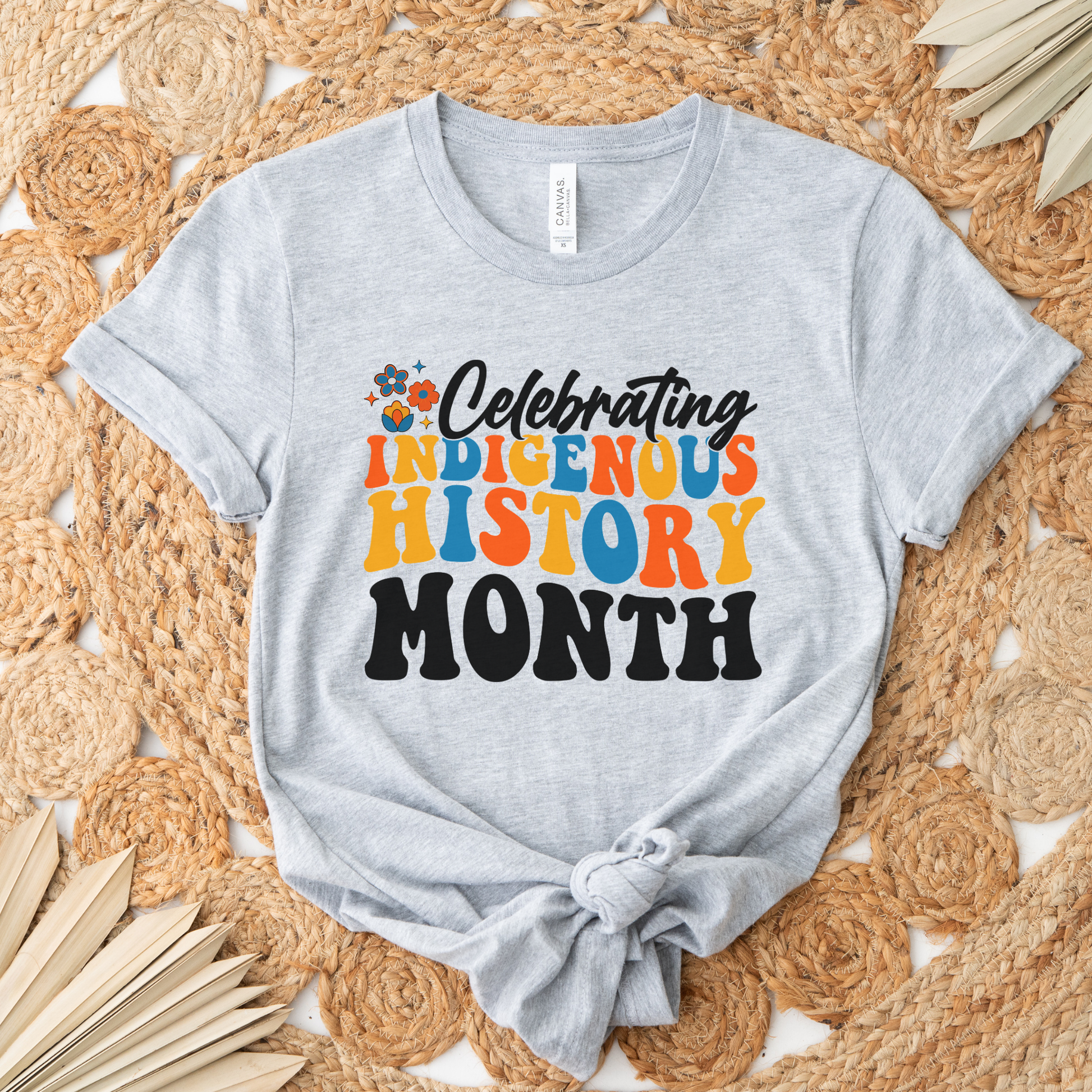 Celebrating Indigenous History Month shirt with colorful text and hand-drawn floral design on a unisex t-shirt. celebrating indigenous history month, indigenous history month shirt, hand drawn florals, sahdeh spruce design, indigenous pride tee, cultural celebration shirt, unisex graphic tee, indigenous apparel, native pride shirt, heritage clothing, meaningful statement tee, everyday wear shirt, community event shirt, indigenous month shirt, floral graphic tee