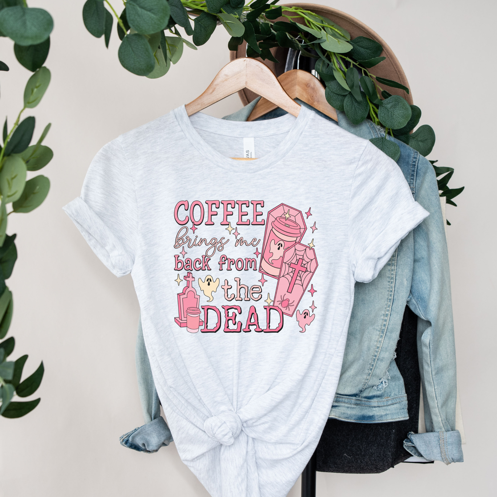 Pink Coffee Brings Me Back From The Dead Shirt featuring cute ghosts, coffee cups, coffins, stars, and spooky aesthetic artwork. coffee shirt, coffee lover shirt, spooky coffee shirt, halloween coffee shirt, ghost shirt, cute ghost shirt, pink halloween shirt, coffee brings me back from the dead, spooky cute shirt, barista shirt, fall shirt, halloween apparel, coffee aesthetic shirt, gothic cute shirt, pink ghost shirt, caffeine lover gift, spooky season shirt, witchy coffee shirt, halloween lover gift
