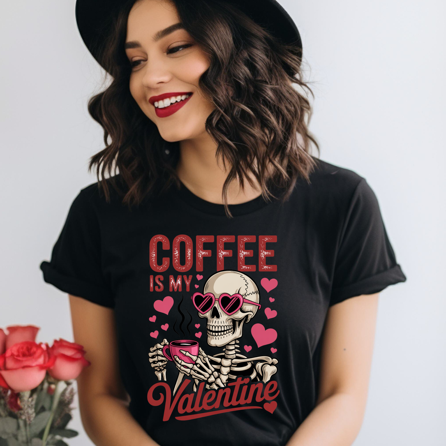 Woman wearing a black t-shirt with a skeleton design and text, standing next to pink roses. coffee shirt, coffee lover tee, valentine shirt, funny valentine shirt, coffee is my valentine, cute coffee shirt, unisex graphic tee, caffeine shirt, gift for coffee lover, funny t shirt, casual tee, valentines day shirt