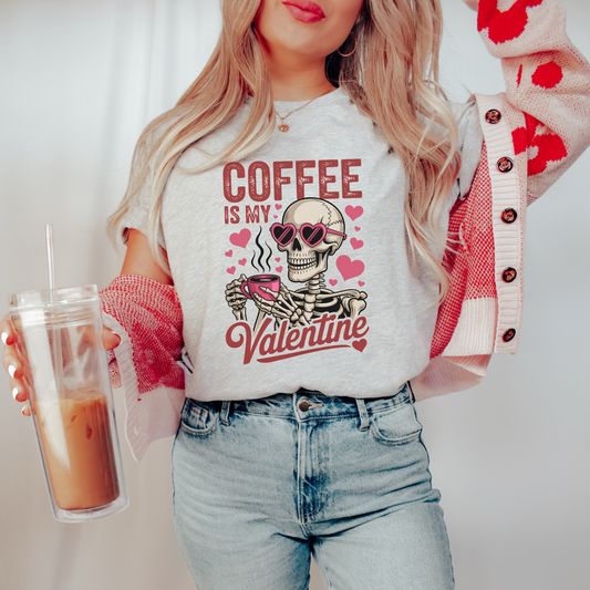 Person wearing a t-shirt with a skeleton design and 'Coffee is my Valentine' text, holding an iced coffee. coffee shirt, coffee lover tee, valentine shirt, funny valentine shirt, coffee is my valentine, cute coffee shirt, unisex graphic tee, caffeine shirt, gift for coffee lover, funny t shirt, casual tee, valentines day shirt