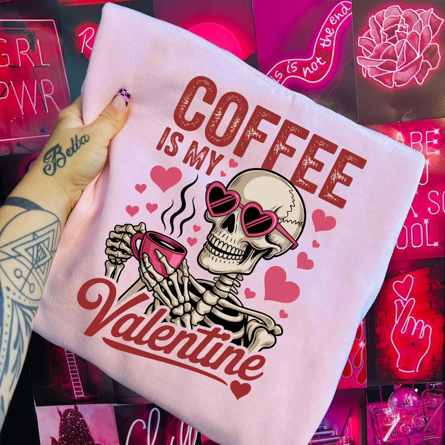 T-shirt with skeleton design and 'Coffee is my Valentine' text, held in front of neon signs. coffee shirt, coffee lover tee, valentine shirt, funny valentine shirt, coffee is my valentine, cute coffee shirt, unisex graphic tee, caffeine shirt, gift for coffee lover, funny t shirt, casual tee, valentines day shirt