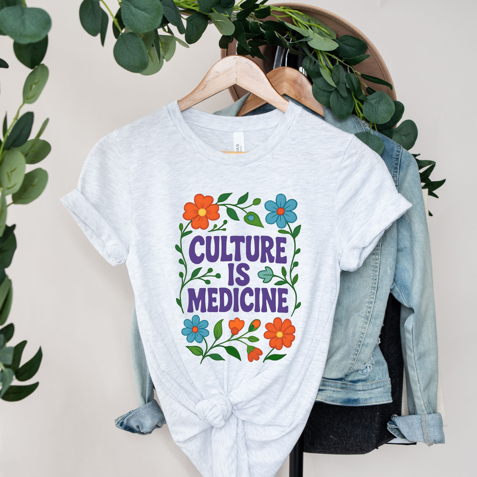 Culture Is Medicine Shirt featuring colorful floral artwork surrounding bold purple lettering. culture is medicine shirt, indigenous shirt, indigenous pride shirt, indigenous apparel, native pride shirt, cultural pride shirt, indigenous history month, national indigenous peoples day, floral shirt, indigenous gift, cultural connection shirt, indigenous woman shirt, reconciliation shirt, indigenous awareness, community shirt, native apparel, indigenous fashion, cultural healing shirt, floral graphic tee