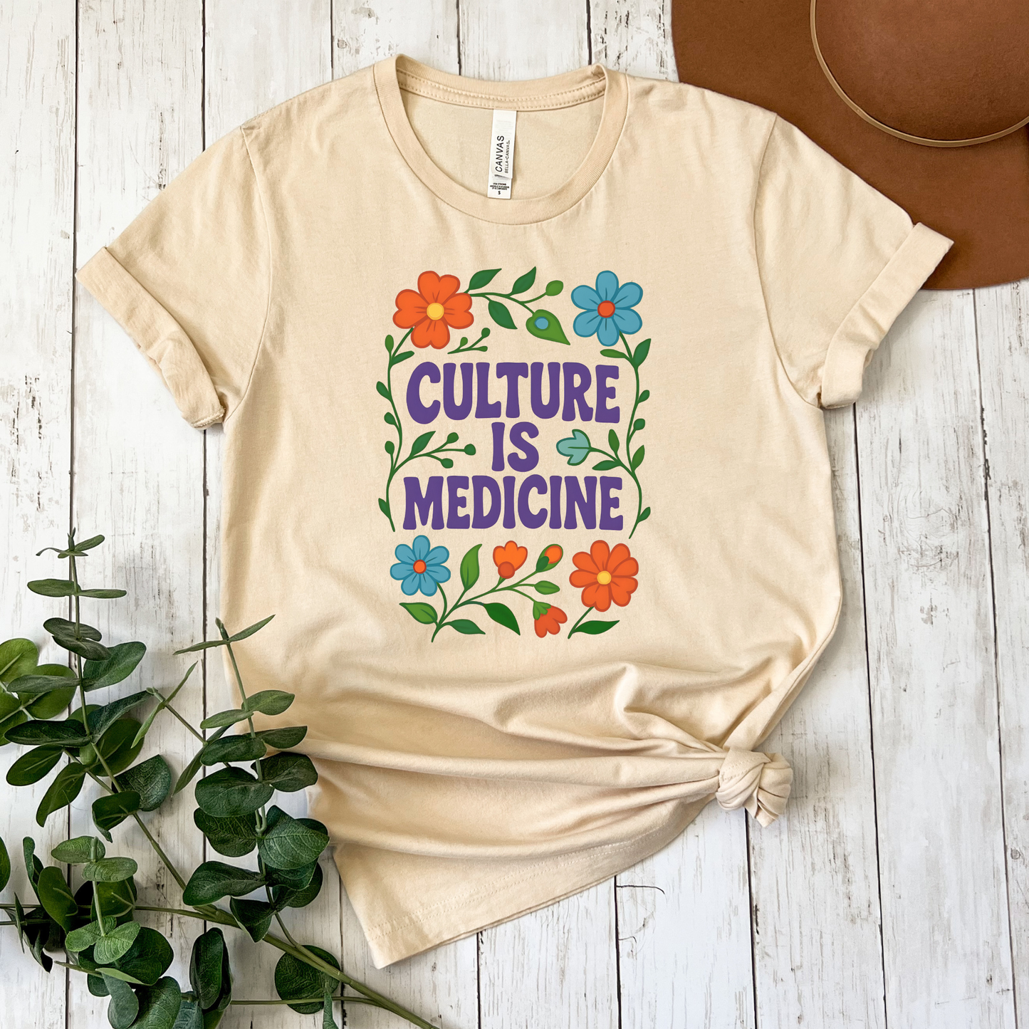 Culture Is Medicine Shirt featuring colorful floral artwork surrounding bold purple lettering. culture is medicine shirt, indigenous shirt, indigenous pride shirt, indigenous apparel, native pride shirt, cultural pride shirt, indigenous history month, national indigenous peoples day, floral shirt, indigenous gift, cultural connection shirt, indigenous woman shirt, reconciliation shirt, indigenous awareness, community shirt, native apparel, indigenous fashion, cultural healing shirt, floral graphic tee