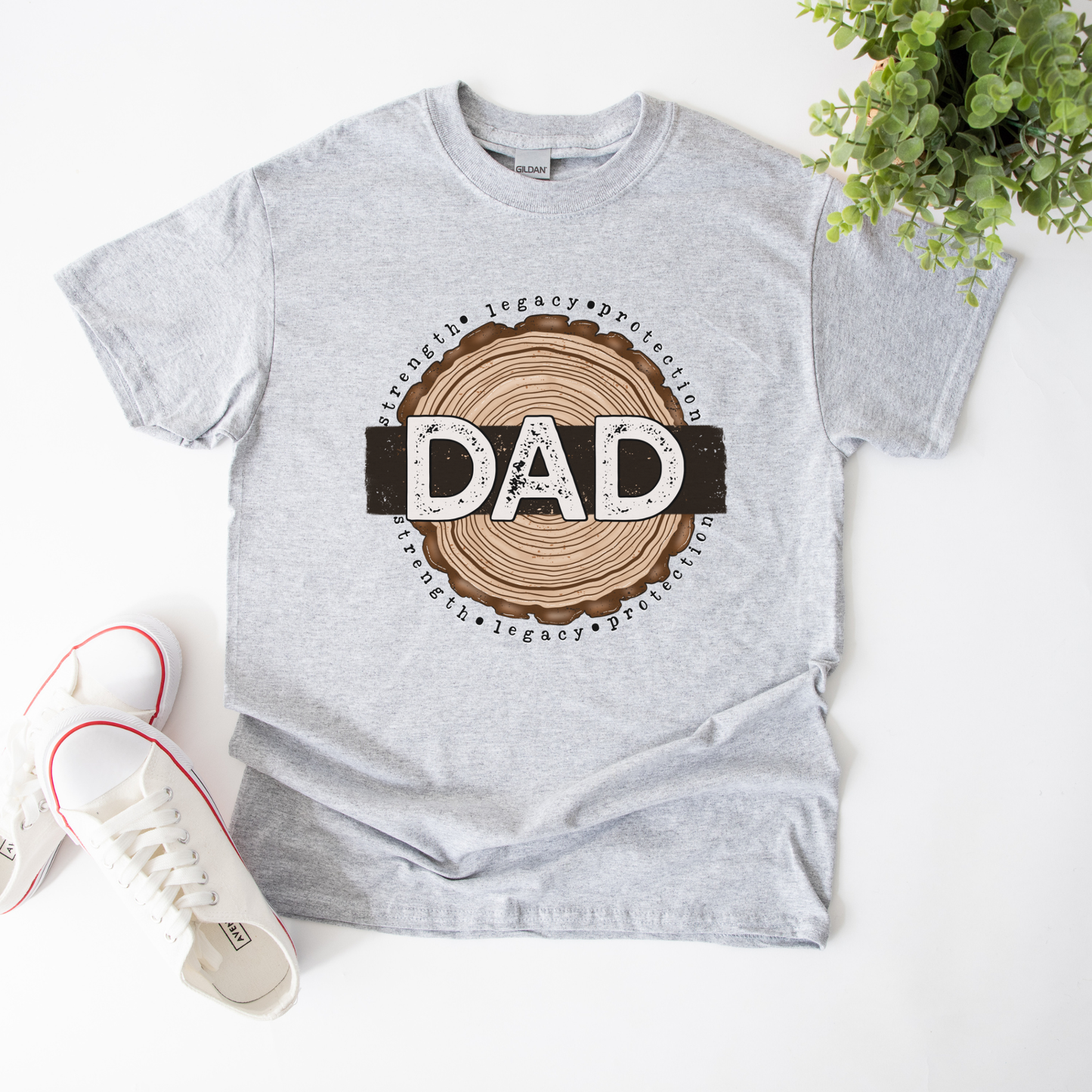 Dad shirt with woodgrain design and the words strength, legacy, protection on a unisex t-shirt. dad shirt, strength legacy protection, father shirt, unisex graphic tee, father’s day shirt, meaningful dad tee, rustic dad shirt, family apparel, dad gift, masculine graphic tee, everyday wear shirt, bold dad design, protective father shirt, legacy shirt, dad lifestyle tee