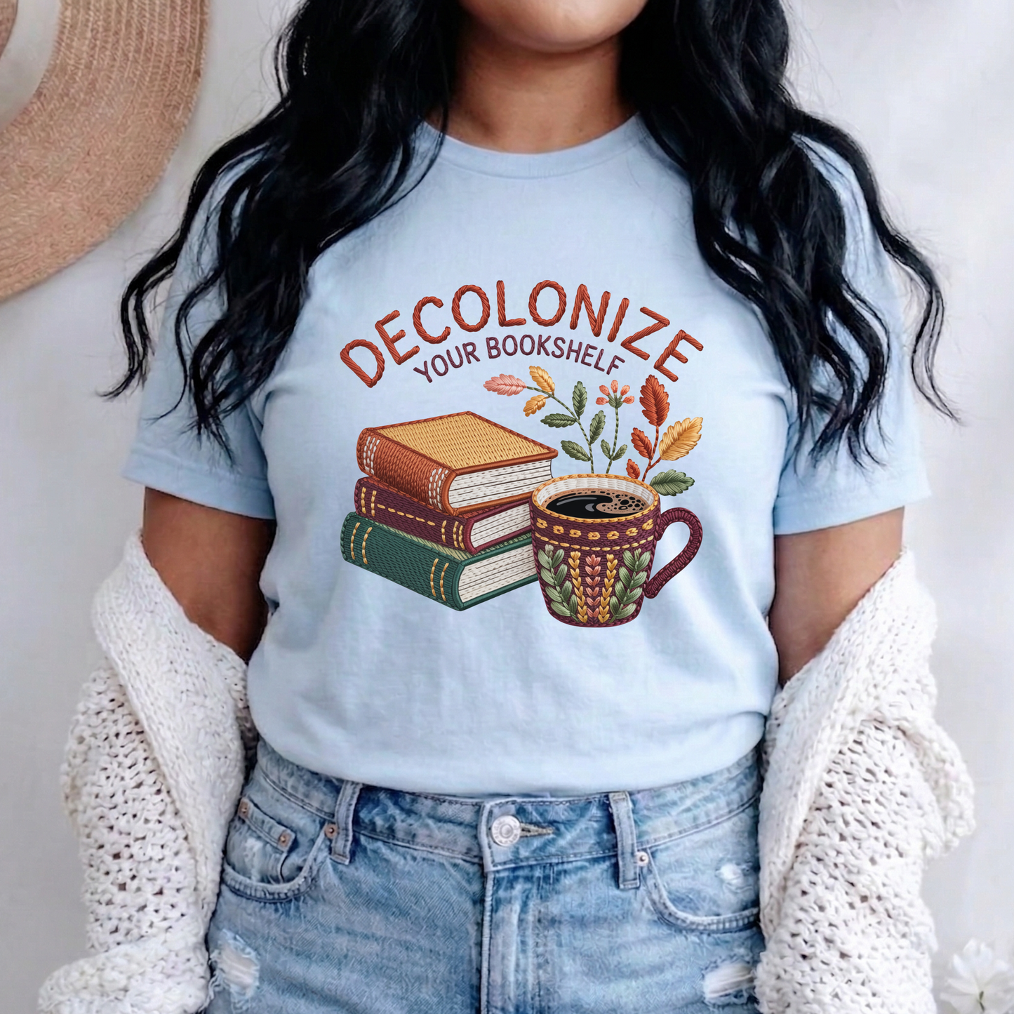 Decolonize Your Bookshelf Shirt featuring stacked books, a floral coffee mug, botanical accents, and embroidered-style lettering. decolonize your bookshelf shirt, book lover shirt, reader shirt, librarian shirt, teacher shirt, bookworm shirt, reading shirt, book club shirt, diverse books shirt, indigenous literature, bookstore shirt, coffee and books, literary shirt, reader gift, librarian gift, teacher gift, book aesthetic shirt, bookish apparel, reading enthusiast, book nerd shirt