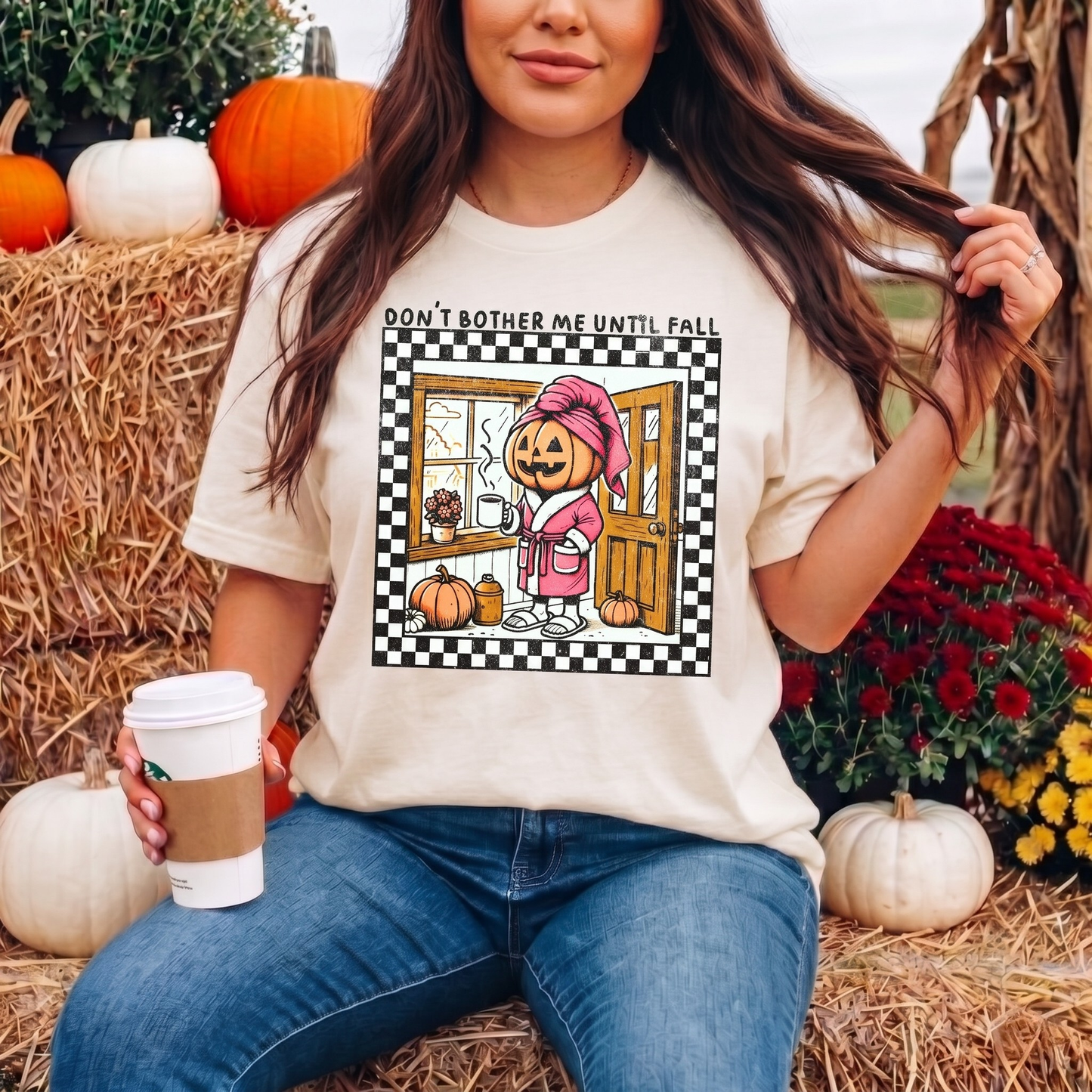 t-shirt featuring a cozy pumpkin character wearing a pink robe and towel, holding a coffee mug with the phrase "Don't Bother Me Until Fall," surrounded by autumn-inspired details and a checkered border. don't bother me until fall shirt, halloween pumpkin shirt, cozy autumn tee, fall lover t-shirt, pumpkin spice season shirt, spooky season apparel, cute pumpkin graphic tee, halloween aesthetic clothing, autumn lover gift, fall festival shirt, pumpkin patch outfit, cozy season clothing, spooky cute graphic te