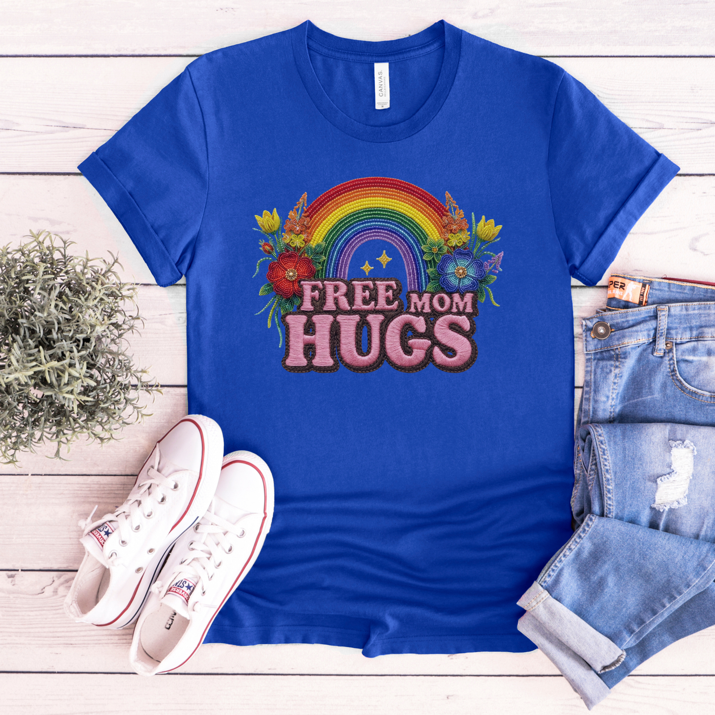 Free Mom Hugs Shirt featuring Indigenous-inspired beaded floral artwork, rainbow design, and pink faux embroidered lettering. free mom hugs shirt, pride shirt, indigenous floral shirt, beaded floral shirt, rainbow pride shirt, lgbtq ally shirt, supportive mom shirt, pride parade shirt, indigenous inspired apparel, faux embroidery shirt, mom hugs shirt, rainbow floral tee, inclusive apparel, pride month shirt, indigenous beadwork design, ally gift, lgbtq support shirt, community love shirt, acceptance shirt