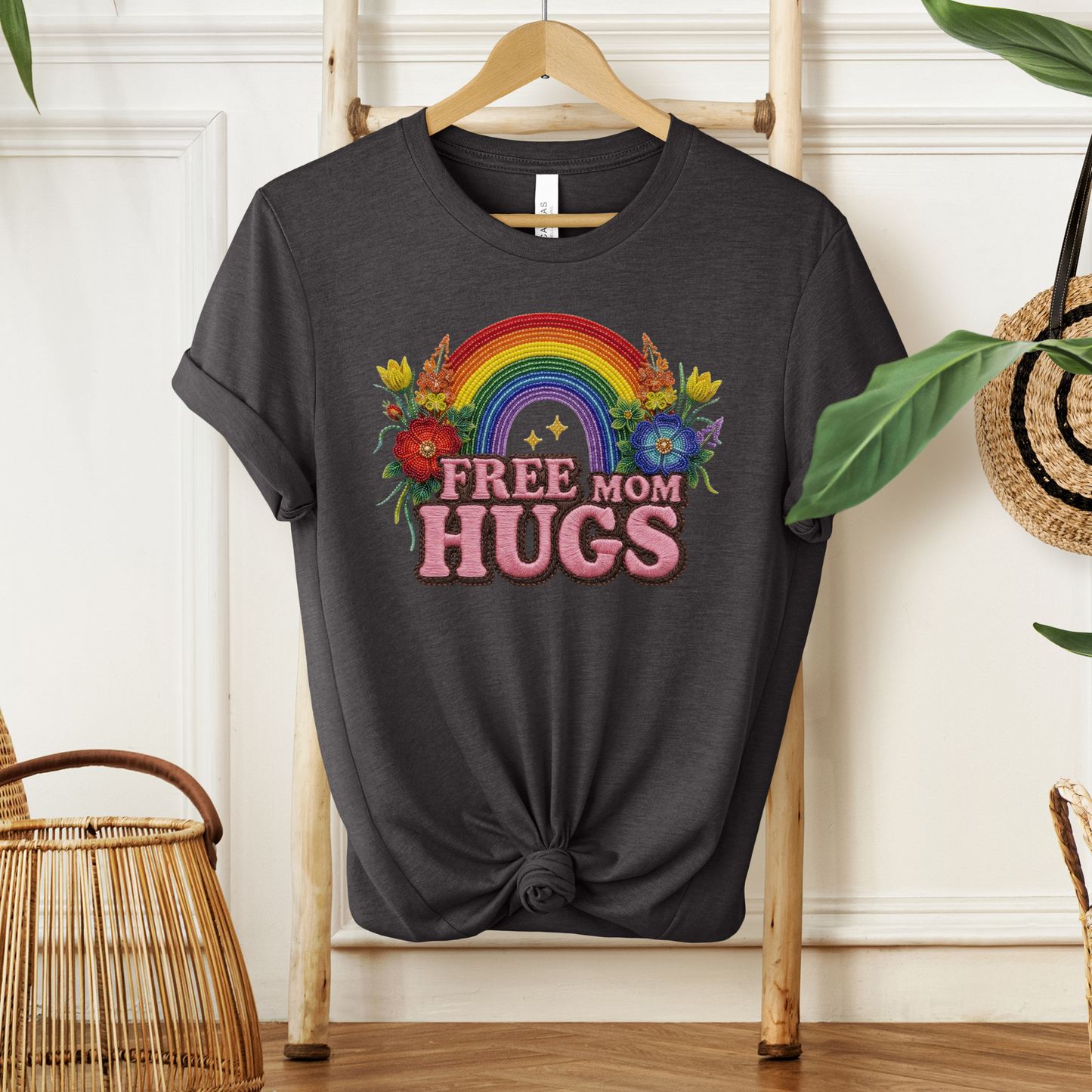 Free Mom Hugs Shirt featuring Indigenous-inspired beaded floral artwork, rainbow design, and pink faux embroidered lettering. free mom hugs shirt, pride shirt, indigenous floral shirt, beaded floral shirt, rainbow pride shirt, lgbtq ally shirt, supportive mom shirt, pride parade shirt, indigenous inspired apparel, faux embroidery shirt, mom hugs shirt, rainbow floral tee, inclusive apparel, pride month shirt, indigenous beadwork design, ally gift, lgbtq support shirt, community love shirt, acceptance shirt
