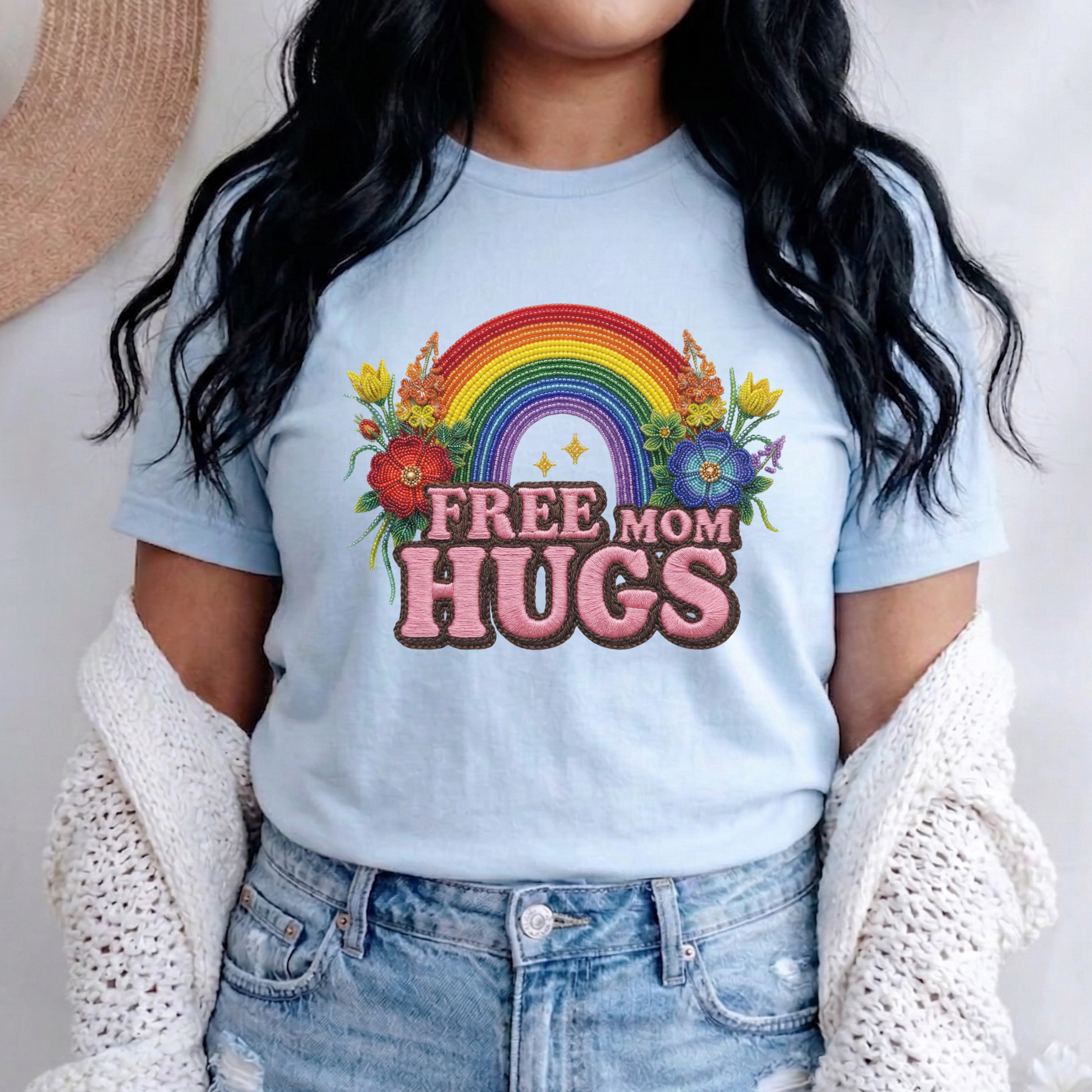 Free Mom Hugs Shirt featuring Indigenous-inspired beaded floral artwork, rainbow design, and pink faux embroidered lettering. free mom hugs shirt, pride shirt, indigenous floral shirt, beaded floral shirt, rainbow pride shirt, lgbtq ally shirt, supportive mom shirt, pride parade shirt, indigenous inspired apparel, faux embroidery shirt, mom hugs shirt, rainbow floral tee, inclusive apparel, pride month shirt, indigenous beadwork design, ally gift, lgbtq support shirt, community love shirt, acceptance shirt
