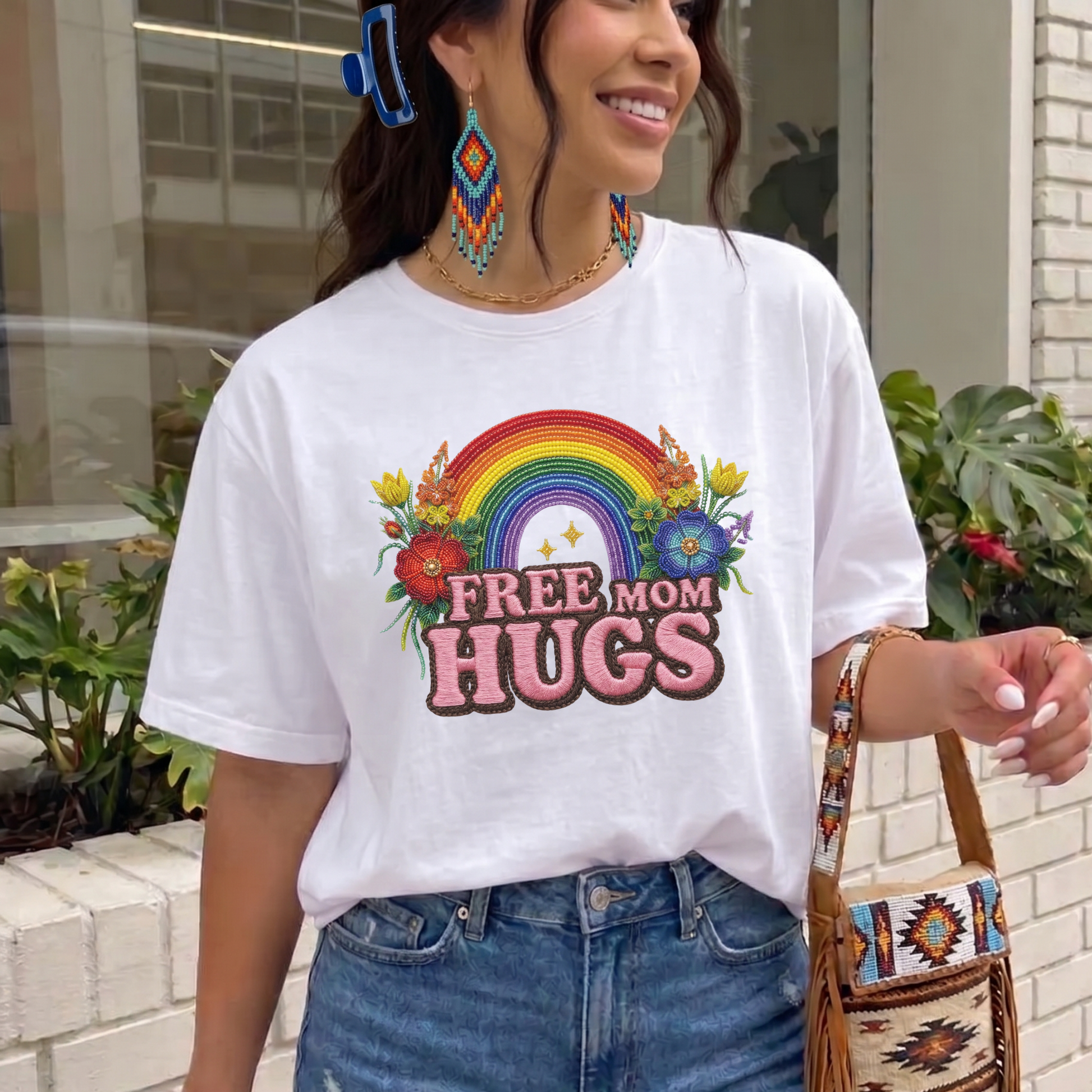 Free Mom Hugs Shirt featuring Indigenous-inspired beaded floral artwork, rainbow design, and pink faux embroidered lettering. free mom hugs shirt, pride shirt, indigenous floral shirt, beaded floral shirt, rainbow pride shirt, lgbtq ally shirt, supportive mom shirt, pride parade shirt, indigenous inspired apparel, faux embroidery shirt, mom hugs shirt, rainbow floral tee, inclusive apparel, pride month shirt, indigenous beadwork design, ally gift, lgbtq support shirt, community love shirt, acceptance shirt