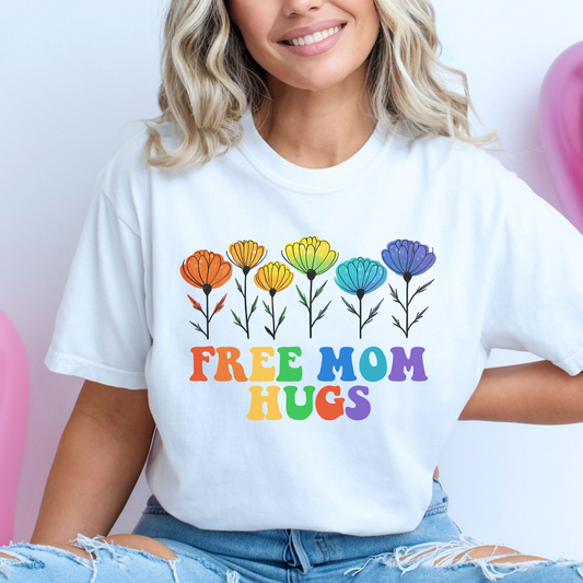 unisex shirt featuring rainbow wildflowers and colourful retro lettering that reads Free Mom Hugs, celebrating LGBTQ2S+ pride, allyship, and inclusion. Free Mom Hugs Shirt, Pride Ally Shirt, LGBTQ2S+ Support Shirt, Rainbow Floral Shirt, Pride Apparel Canada, LGBTQ Ally Tee, Free Hugs Shirt, Rainbow Wildflower Tee, Inclusive Apparel, Pride Month Clothing