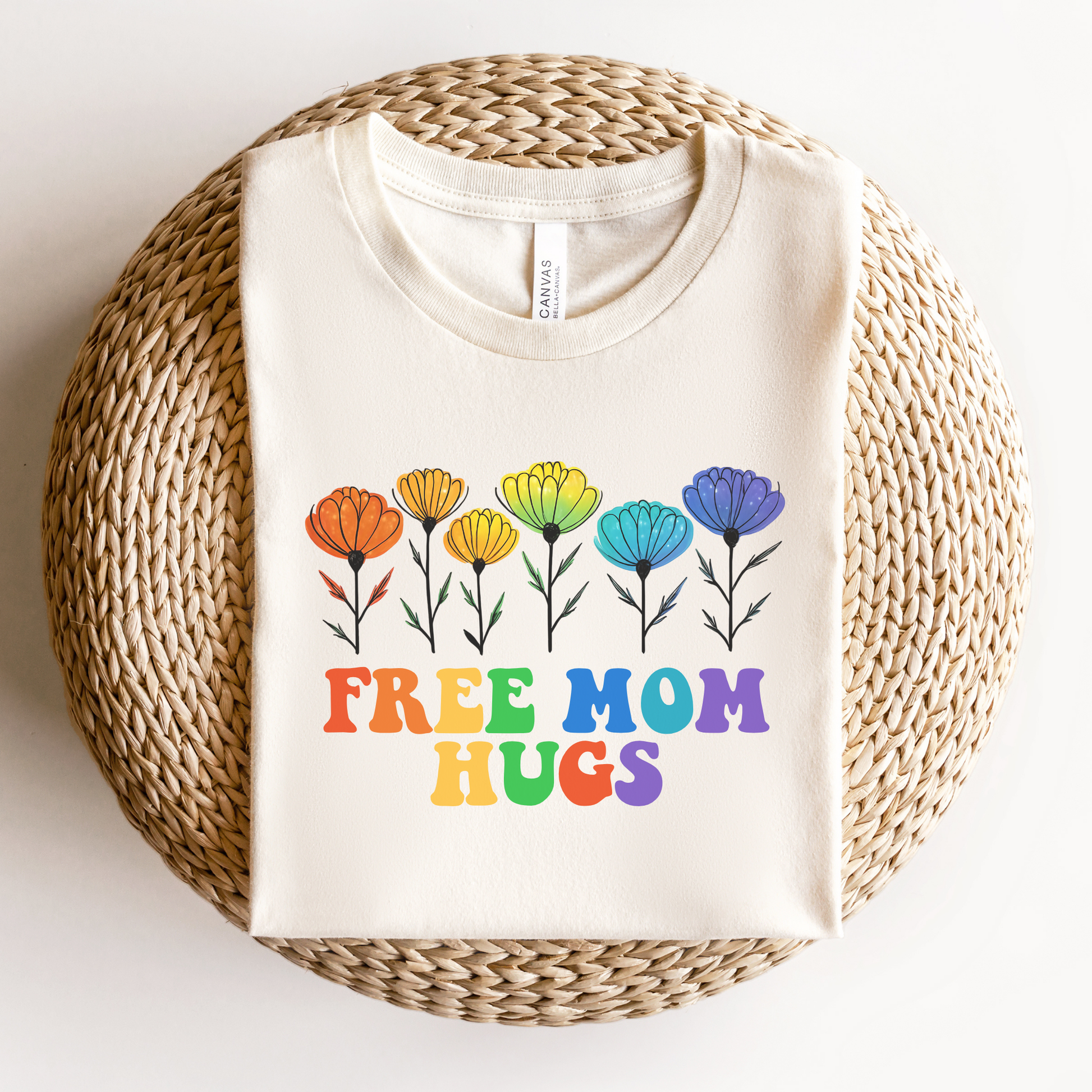 unisex shirt featuring rainbow wildflowers and colourful retro lettering that reads Free Mom Hugs, celebrating LGBTQ2S+ pride, allyship, and inclusion. Free Mom Hugs Shirt, Pride Ally Shirt, LGBTQ2S+ Support Shirt, Rainbow Floral Shirt, Pride Apparel Canada, LGBTQ Ally Tee, Free Hugs Shirt, Rainbow Wildflower Tee, Inclusive Apparel, Pride Month Clothing