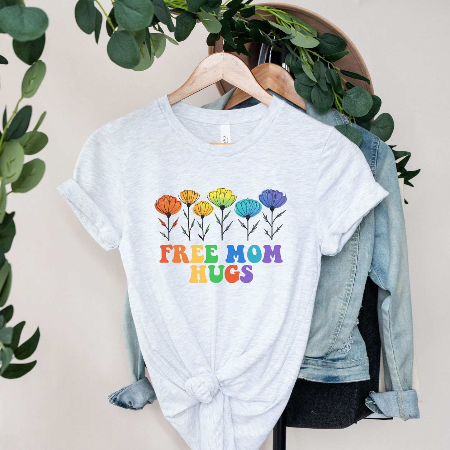 unisex shirt featuring rainbow wildflowers and colourful retro lettering that reads Free Mom Hugs, celebrating LGBTQ2S+ pride, allyship, and inclusion. Free Mom Hugs Shirt, Pride Ally Shirt, LGBTQ2S+ Support Shirt, Rainbow Floral Shirt, Pride Apparel Canada, LGBTQ Ally Tee, Free Hugs Shirt, Rainbow Wildflower Tee, Inclusive Apparel, Pride Month Clothing