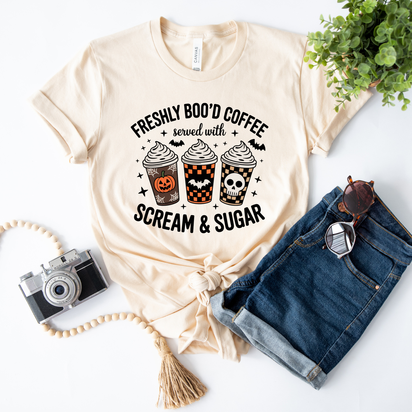 Funny Halloween coffee shirt featuring three festive coffee cups with pumpkins, bats, checkerboard patterns, and skull artwork that reads "Freshly Boo'd Coffee Served With Scream & Sugar." freshly boo'd coffee shirt, scream and sugar shirt, halloween coffee shirt, spooky coffee shirt, coffee lover halloween shirt, pumpkin spice shirt, fall coffee shirt, cute halloween tee, halloween graphic tee, spooky season shirt, pumpkin patch outfit, coffee addict shirt, funny coffee shirt, halloween apparel
