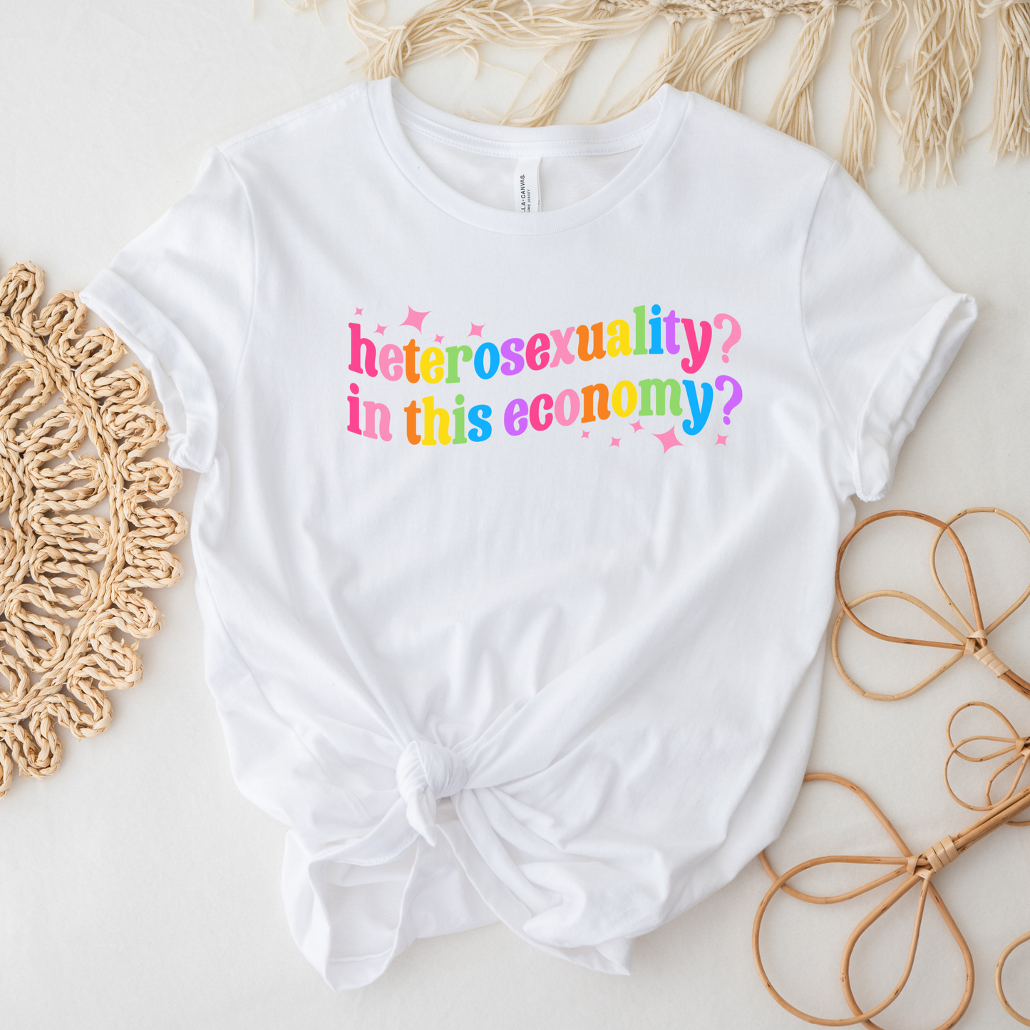 White t-shirt with colorful text on a light background heterosexuality in this economy, funny lgbt shirt, queer humor tee, sarcastic shirt, pride statement tee, unisex graphic tee, funny quote shirt, LGBTQ apparel, humor t shirt, statement tee, witty pride shirt, sarcastic graphic tee, queer fashion, funny unisex shirt, pride humor shirt