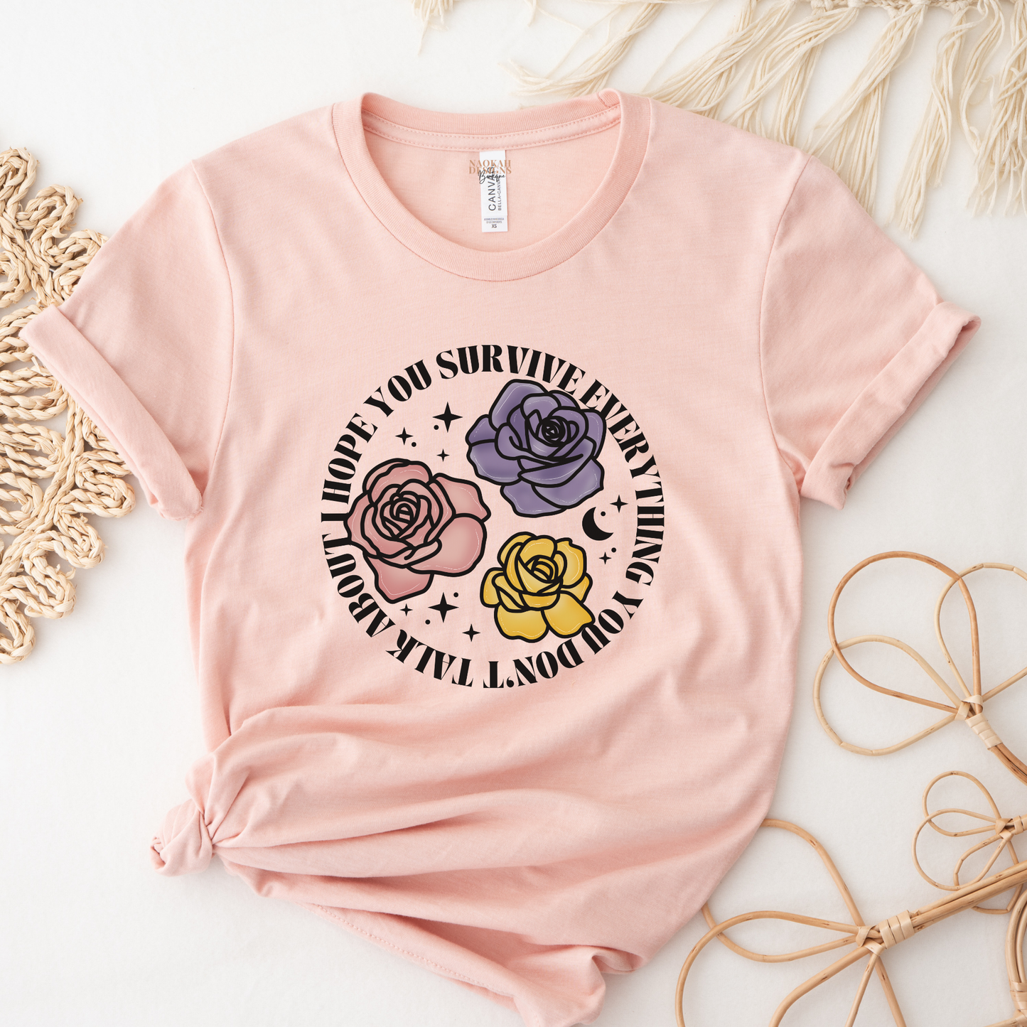 Inspirational floral shirt design featuring three roses in pink, lavender, and yellow with the phrase "I Hope You Survive Everything You Don't Talk About." Mental Health Awareness, Inspirational Shirt, Floral Shirt, Rose Shirt, Encouragement Gift, Self Care Apparel, Positive Message Tee, Inspirational Tee, Floral Graphic Shirt, Unisex T-Shirt, Wellness Apparel, Support Gift, Meaningful Clothing, Floral Fashion, Motivational Shirt, Kindness Matters, Mental Health Support, Graphic Tee, Gift For Her, Gift For 