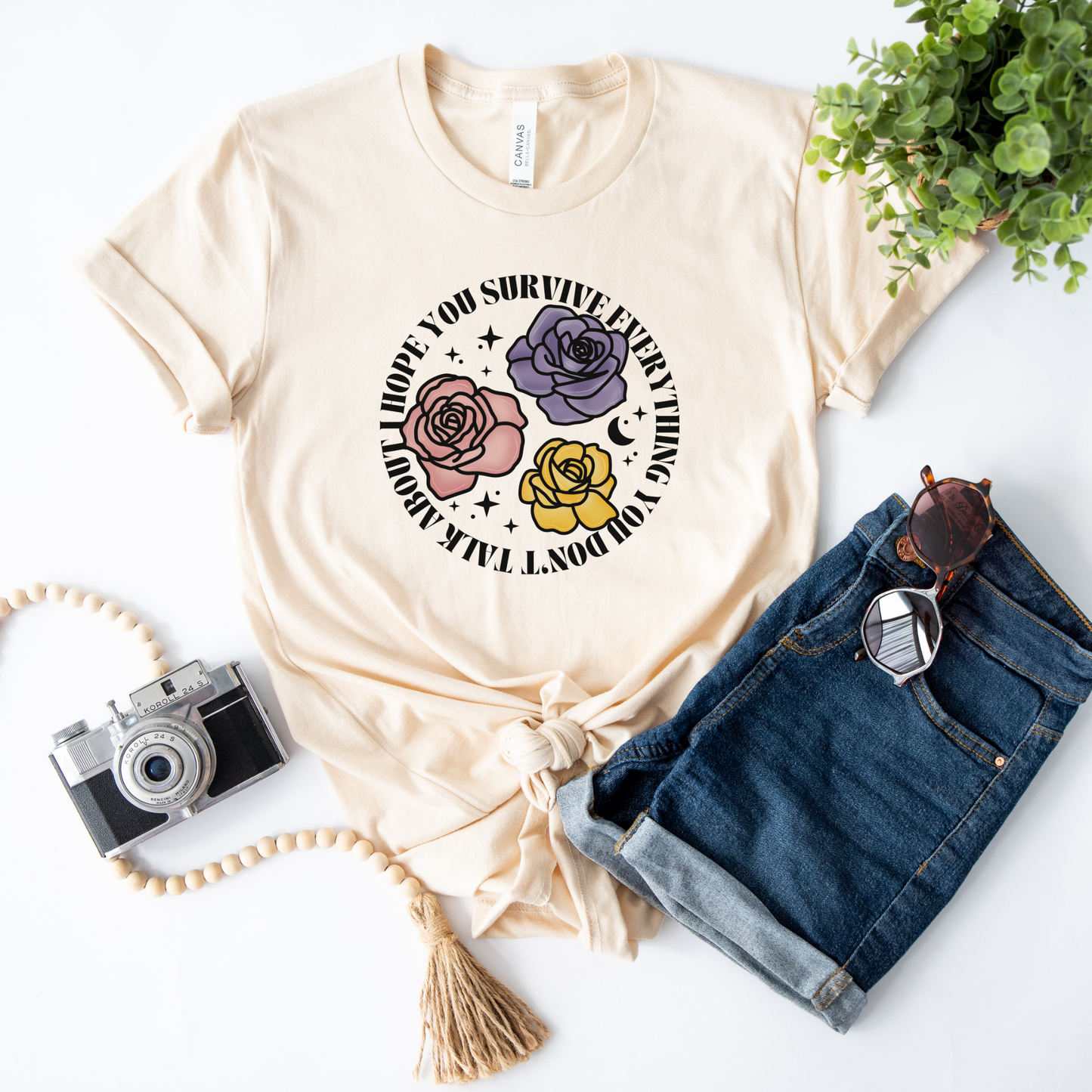 Inspirational floral shirt design featuring three roses in pink, lavender, and yellow with the phrase "I Hope You Survive Everything You Don't Talk About." Mental Health Awareness, Inspirational Shirt, Floral Shirt, Rose Shirt, Encouragement Gift, Self Care Apparel, Positive Message Tee, Inspirational Tee, Floral Graphic Shirt, Unisex T-Shirt, Wellness Apparel, Support Gift, Meaningful Clothing, Floral Fashion, Motivational Shirt, Kindness Matters, Mental Health Support, Graphic Tee, Gift For Her, Gift For 