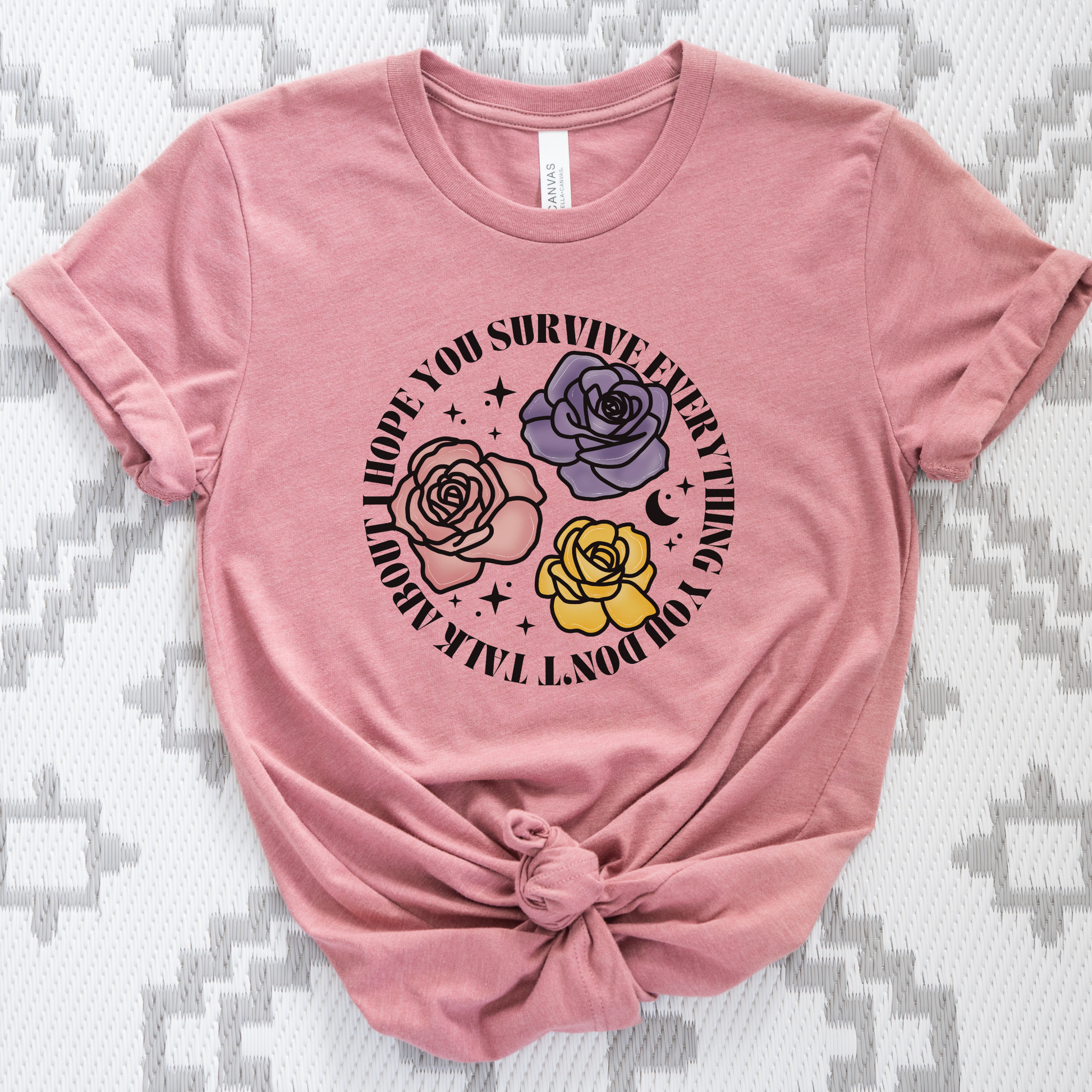 Inspirational floral shirt design featuring three roses in pink, lavender, and yellow with the phrase "I Hope You Survive Everything You Don't Talk About." Mental Health Awareness, Inspirational Shirt, Floral Shirt, Rose Shirt, Encouragement Gift, Self Care Apparel, Positive Message Tee, Inspirational Tee, Floral Graphic Shirt, Unisex T-Shirt, Wellness Apparel, Support Gift, Meaningful Clothing, Floral Fashion, Motivational Shirt, Kindness Matters, Mental Health Support, Graphic Tee, Gift For Her, Gift For 