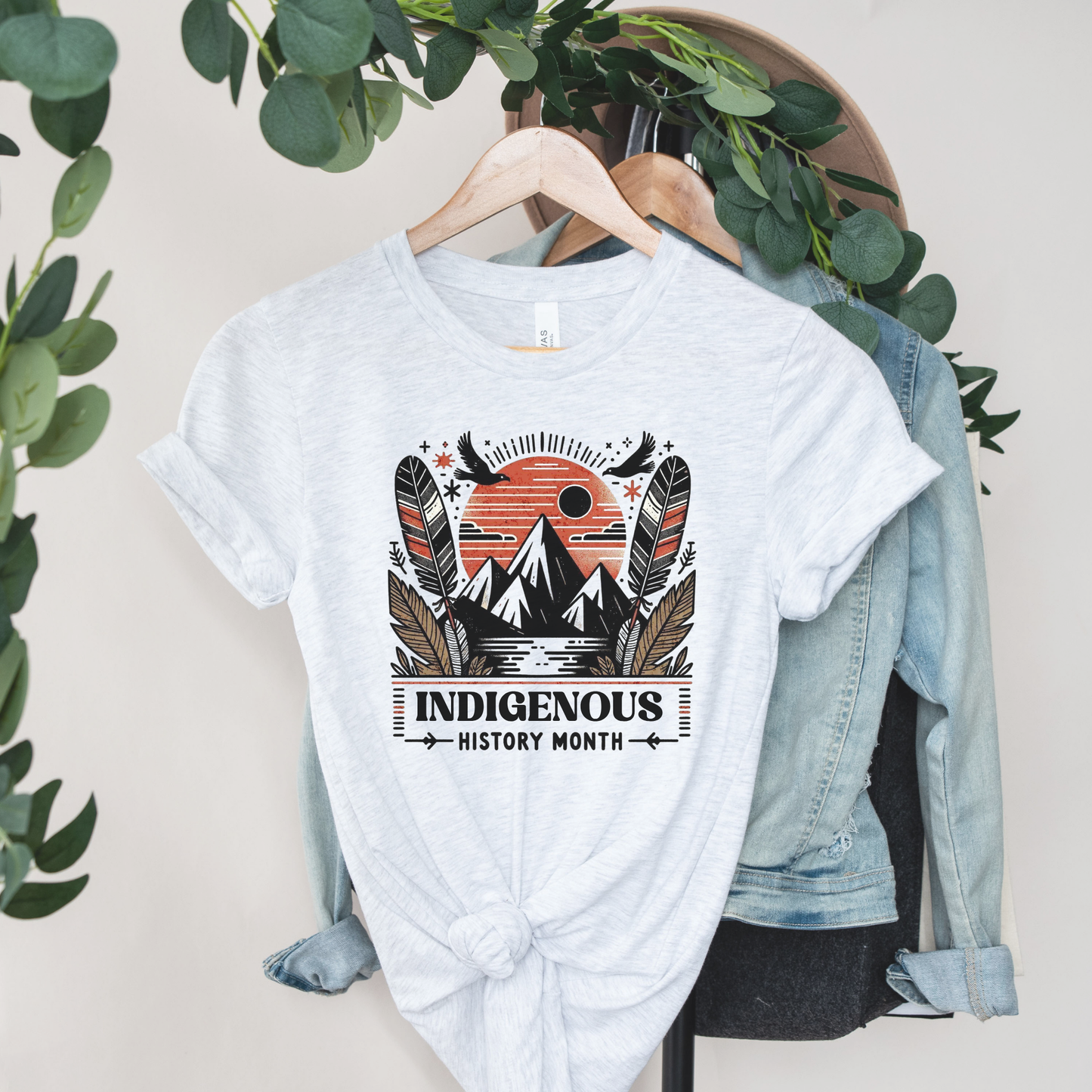Indigenous History Month shirt with mountain, feather, and sun graphic in black, white, and earth tones on a unisex t-shirt. indigenous history month shirt, indigenous pride tee, mountain feather sun design, unisex graphic tee, cultural celebration shirt, indigenous apparel, native pride shirt, heritage clothing, meaningful statement tee, everyday wear shirt, community event shirt, indigenous month shirt, bold graphic tee, indigenous history apparel, celebration shirt
