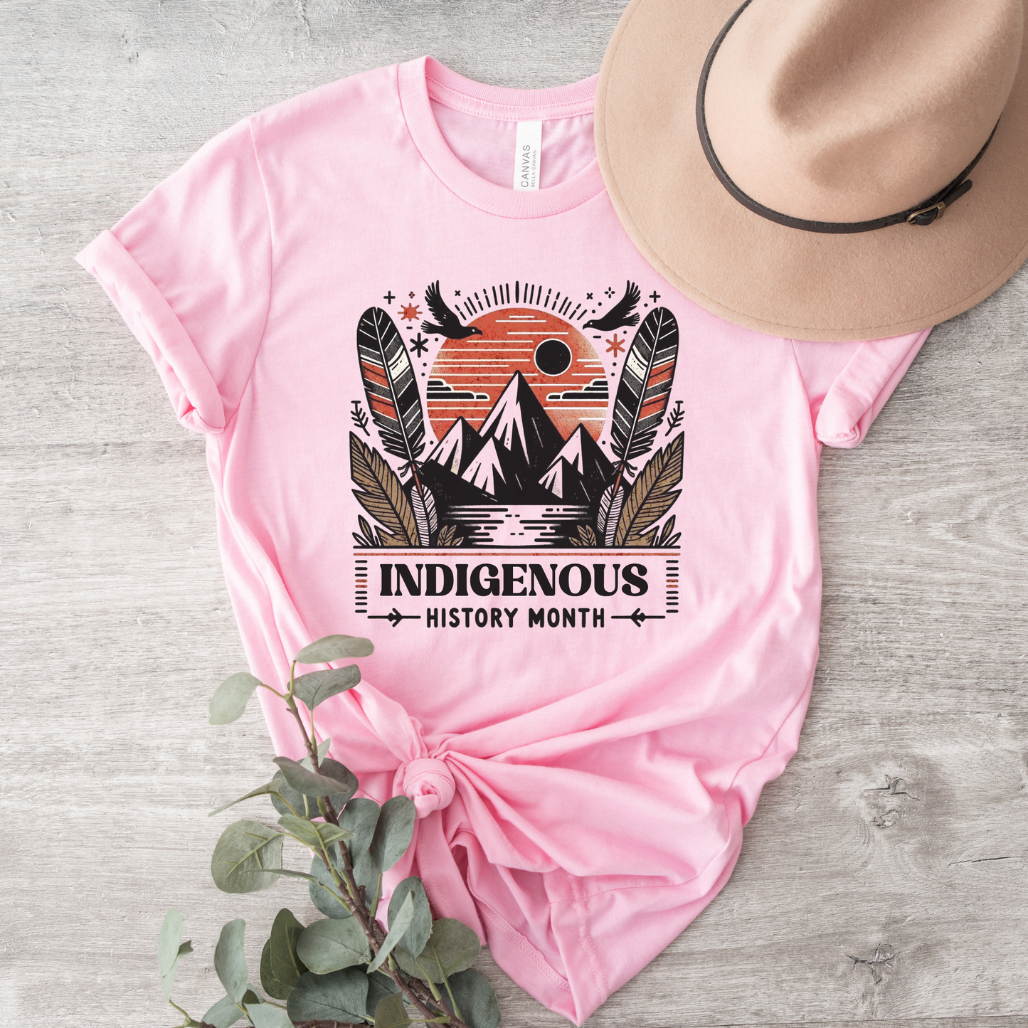 Indigenous History Month shirt with mountain, feather, and sun graphic in black, white, and earth tones on a unisex t-shirt. indigenous history month shirt, indigenous pride tee, mountain feather sun design, unisex graphic tee, cultural celebration shirt, indigenous apparel, native pride shirt, heritage clothing, meaningful statement tee, everyday wear shirt, community event shirt, indigenous month shirt, bold graphic tee, indigenous history apparel, celebration shirt