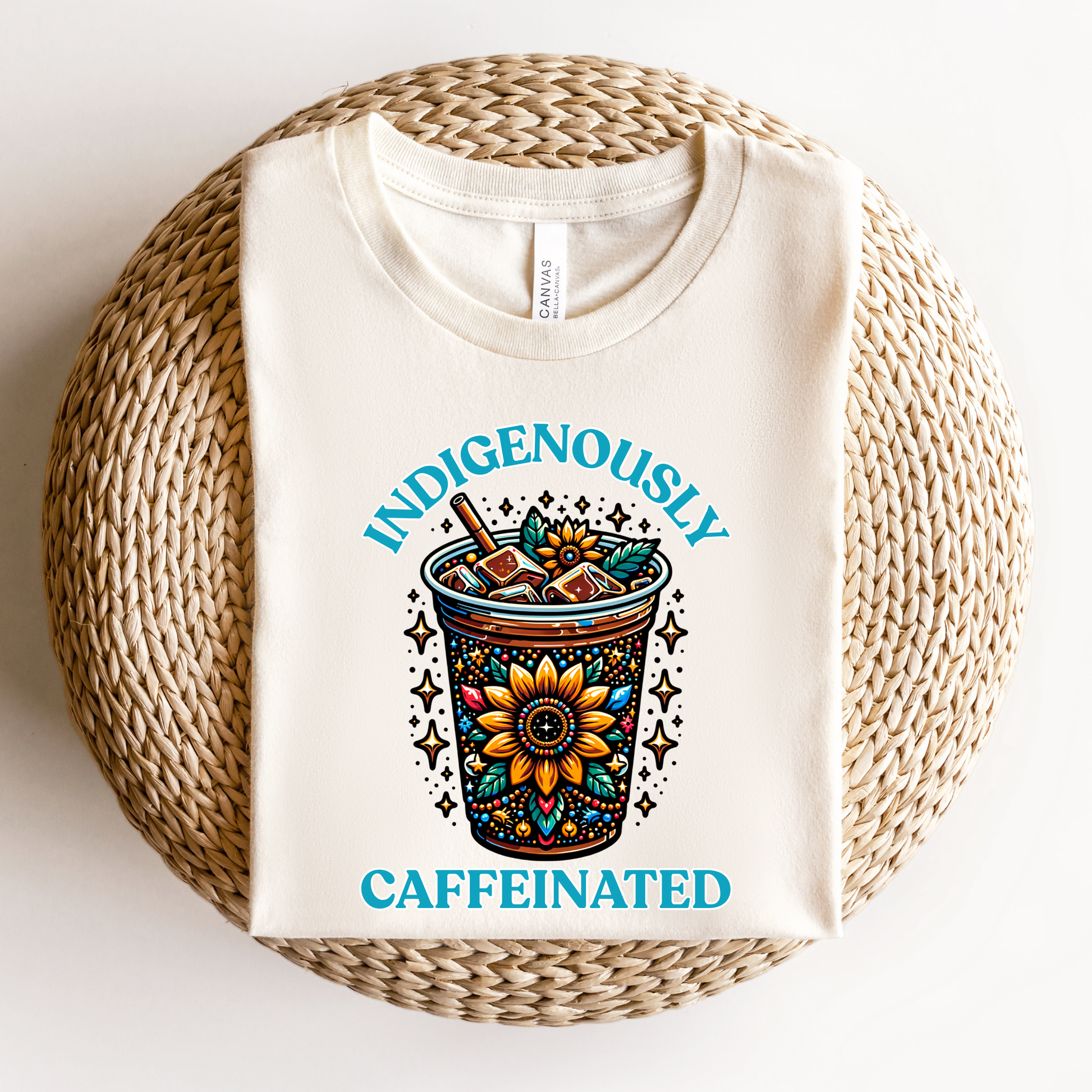 t-shirt featuring a vibrant Indigenous-inspired floral iced coffee design with the phrase "Indigenously Caffeinated" in turquoise lettering. indigenously caffeinated shirt, indigenous coffee lover shirt, indigenous graphic tee, native coffee shirt, coffee lover apparel, indigenous pride clothing, floral coffee design shirt, indigenous entrepreneur shirt, caffeine lover gift, indigenous fashion canada, indigenous art t-shirt, iced coffee graphic tee, indigenous gift ideas, coffee addict shirt, indigenous sma