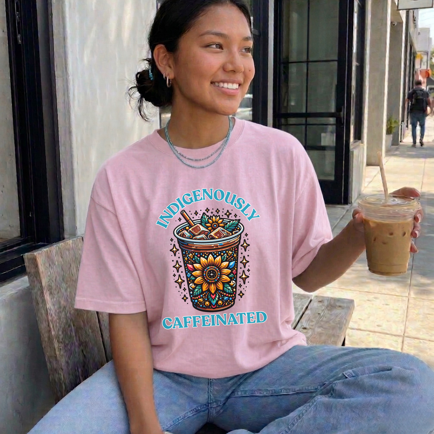 t-shirt featuring a vibrant Indigenous-inspired floral iced coffee design with the phrase "Indigenously Caffeinated" in turquoise lettering. indigenously caffeinated shirt, indigenous coffee lover shirt, indigenous graphic tee, native coffee shirt, coffee lover apparel, indigenous pride clothing, floral coffee design shirt, indigenous entrepreneur shirt, caffeine lover gift, indigenous fashion canada, indigenous art t-shirt, iced coffee graphic tee, indigenous gift ideas, coffee addict shirt, indigenous sma