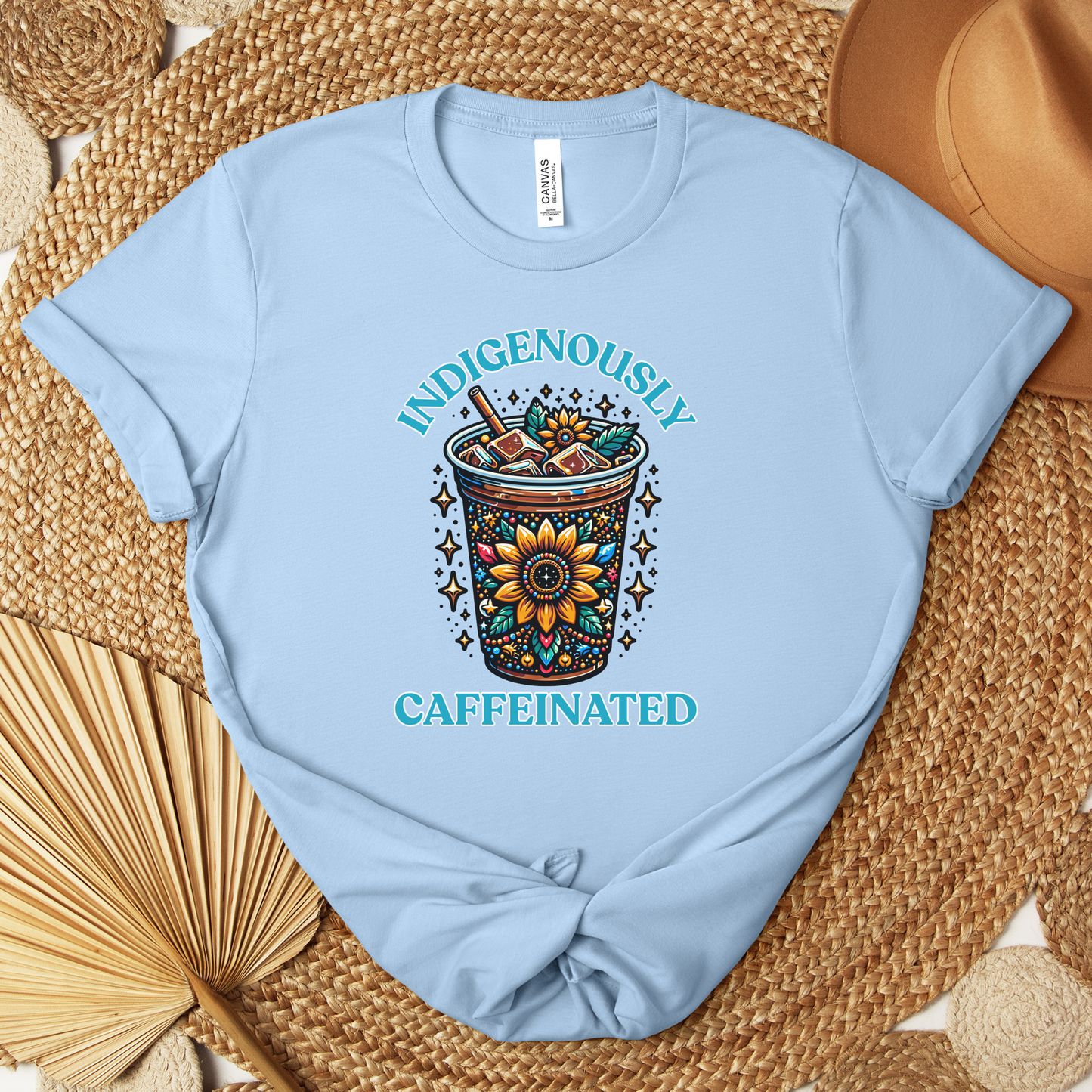 t-shirt featuring a vibrant Indigenous-inspired floral iced coffee design with the phrase "Indigenously Caffeinated" in turquoise lettering. indigenously caffeinated shirt, indigenous coffee lover shirt, indigenous graphic tee, native coffee shirt, coffee lover apparel, indigenous pride clothing, floral coffee design shirt, indigenous entrepreneur shirt, caffeine lover gift, indigenous fashion canada, indigenous art t-shirt, iced coffee graphic tee, indigenous gift ideas, coffee addict shirt, indigenous sma