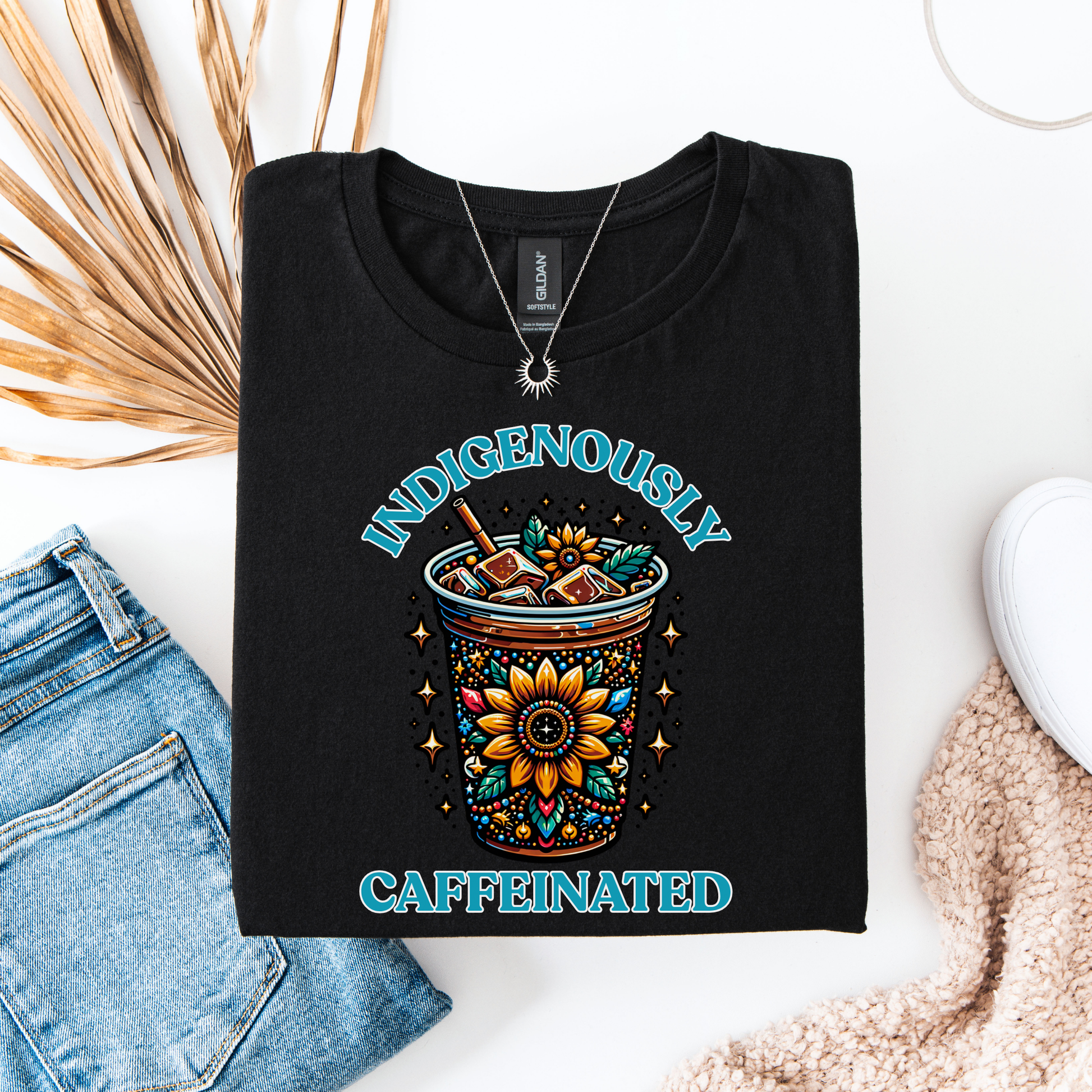t-shirt featuring a vibrant Indigenous-inspired floral iced coffee design with the phrase "Indigenously Caffeinated" in turquoise lettering. indigenously caffeinated shirt, indigenous coffee lover shirt, indigenous graphic tee, native coffee shirt, coffee lover apparel, indigenous pride clothing, floral coffee design shirt, indigenous entrepreneur shirt, caffeine lover gift, indigenous fashion canada, indigenous art t-shirt, iced coffee graphic tee, indigenous gift ideas, coffee addict shirt, indigenous sma