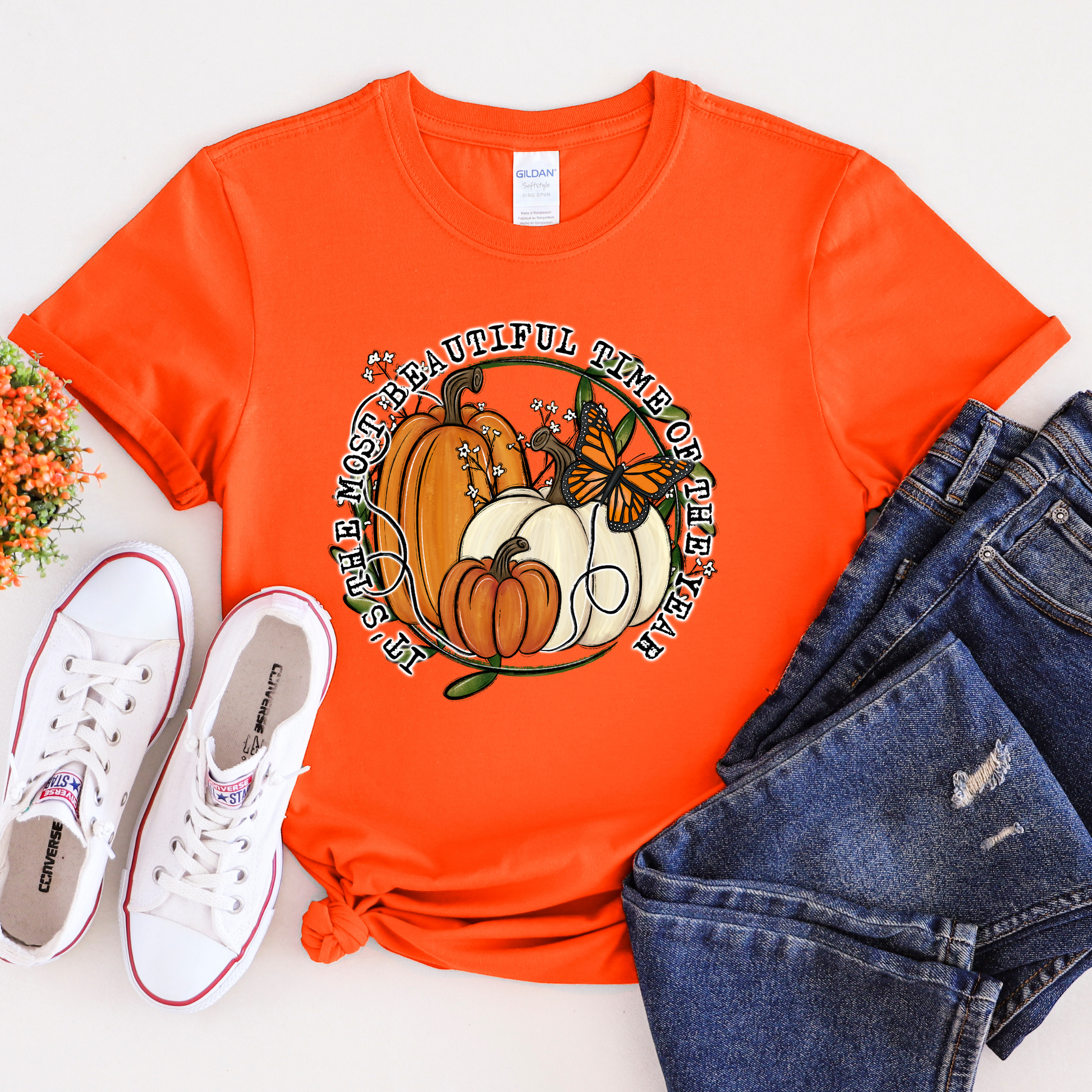 unisex t-shirt featuring pumpkins, a monarch butterfly, leafy accents, and the phrase "It's The Most Beautiful Time Of The Year" in a circular autumn-inspired design. it's the most beautiful time of the year shirt, fall shirt, autumn shirt, pumpkin shirt, pumpkin season shirt, thanksgiving shirt, fall graphic tee, cozy autumn shirt, pumpkin patch shirt, sweater weather shirt, fall aesthetic, harvest shirt, halloween shirt, pumpkin lover gift, autumn outfit, farmhouse fall decor shirt, monarch butterfly
