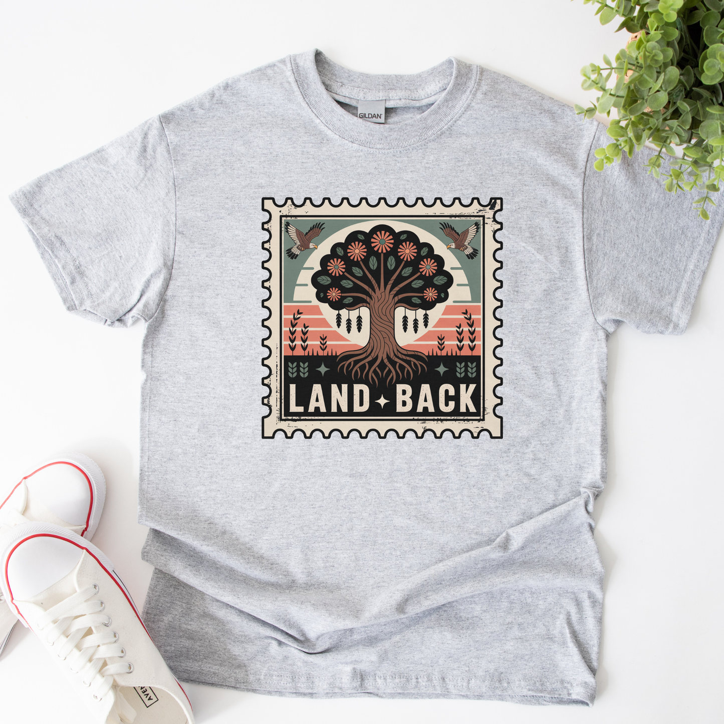 Gray t-shirt with a graphic design featuring a tree and 'Land Back' text on a white surface. land back shirt, indigenous awareness shirt, nature shirt, tree graphic tee, minimalist shirt, advocacy apparel, eco conscious clothing, indigenous inspired apparel, social justice shirt, unisex t shirt, earthy aesthetic clothing, statement tee