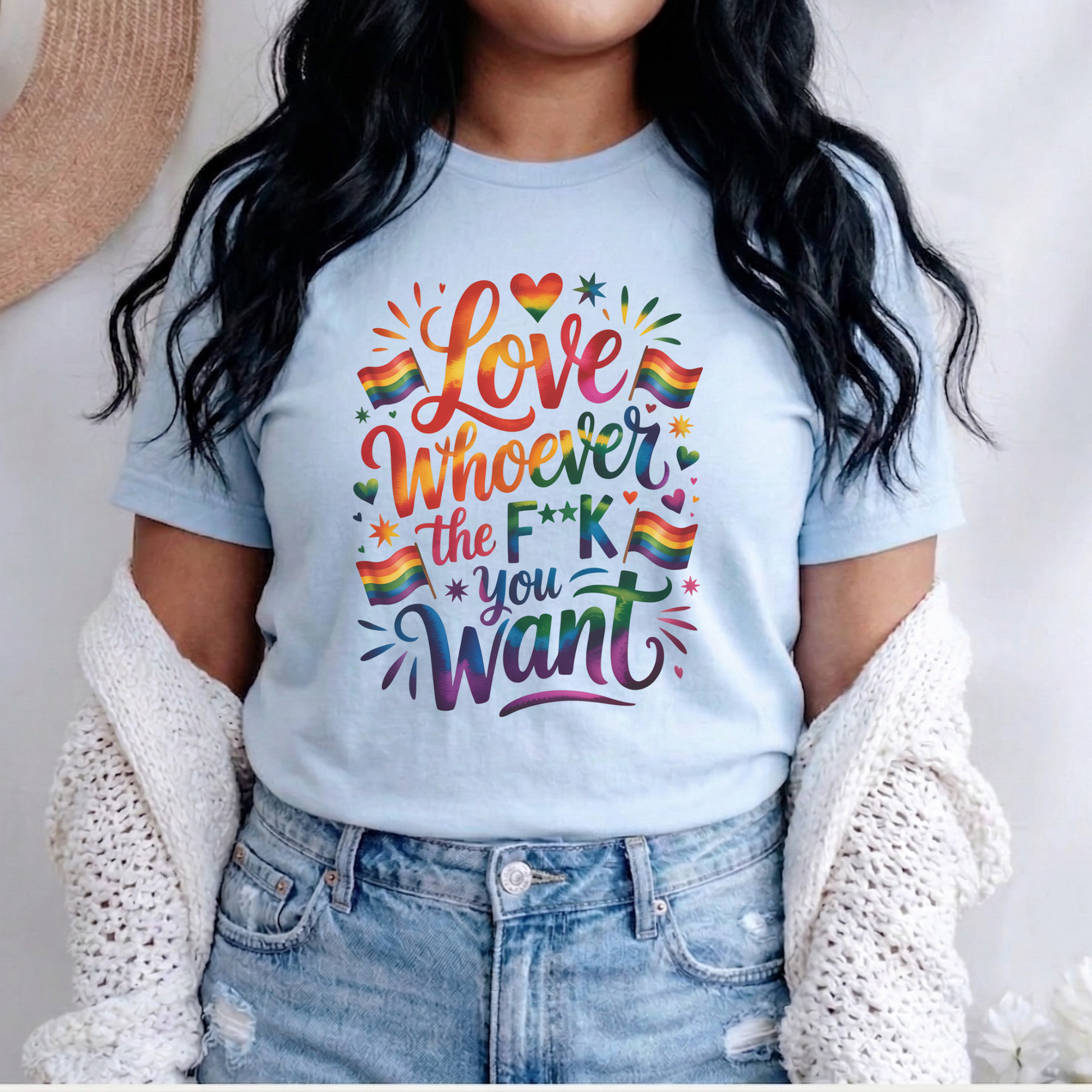 Person wearing a light blue t-shirt with colorful text and rainbow flags. love is love, pride shirt, equality apparel, inclusive clothing, feminist tee, graphic shirt, LGBTQ+ fashion, Indigenous brand, Toronto streetwear, statement tee, self-expression shirt