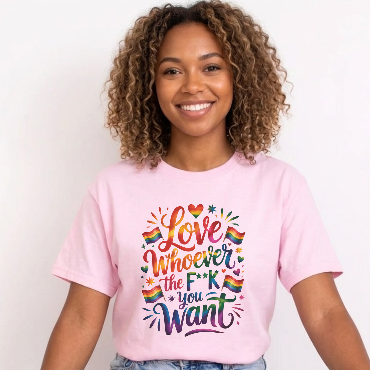 Person wearing a pink t-shirt with colorful text and rainbow hearts on a plain background. love is love, pride shirt, equality apparel, inclusive clothing, feminist tee, graphic shirt, LGBTQ+ fashion, Indigenous brand, Toronto streetwear, statement tee, self-expression shirt