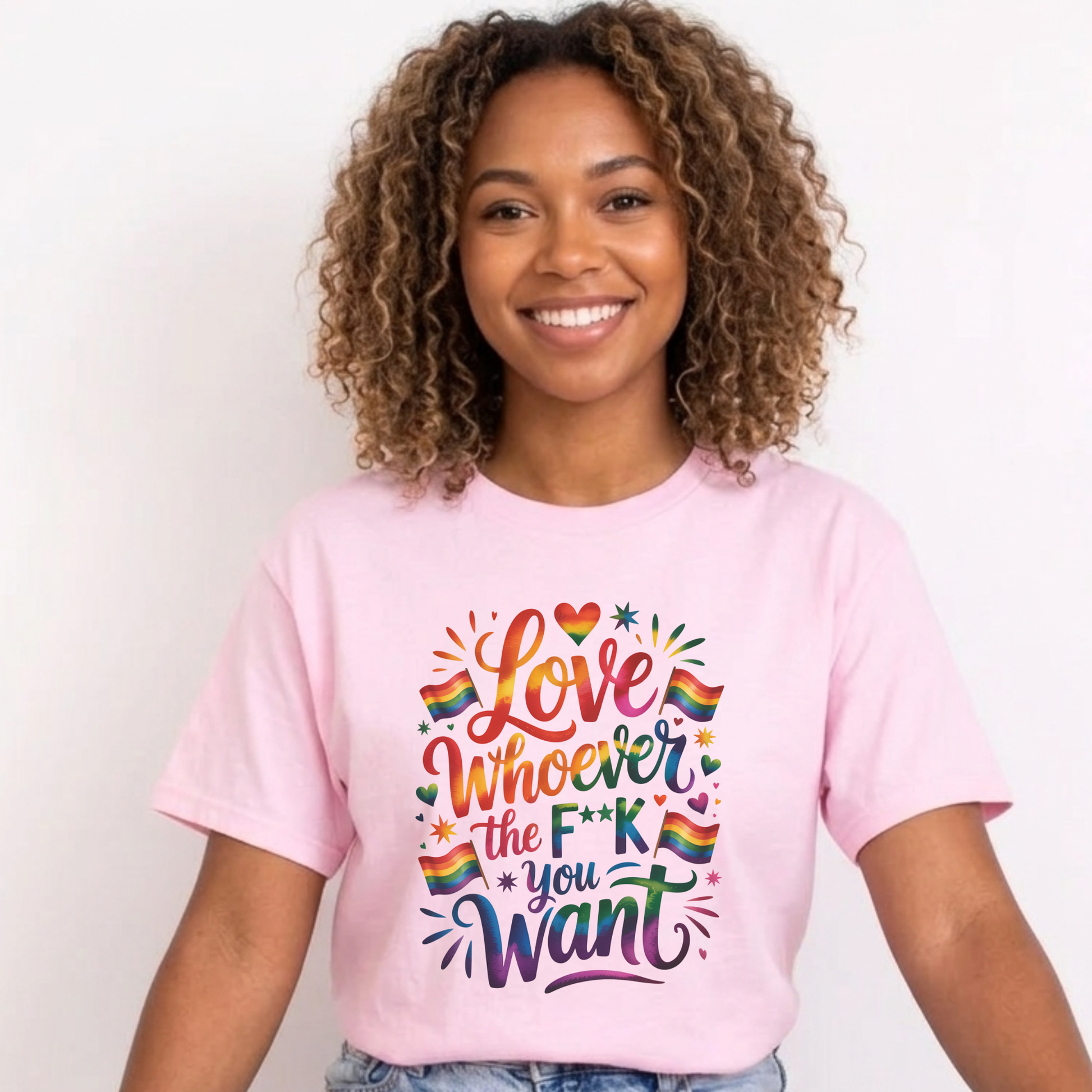 Person wearing a pink t-shirt with colorful text and rainbow hearts on a plain background. love is love, pride shirt, equality apparel, inclusive clothing, feminist tee, graphic shirt, LGBTQ+ fashion, Indigenous brand, Toronto streetwear, statement tee, self-expression shirt