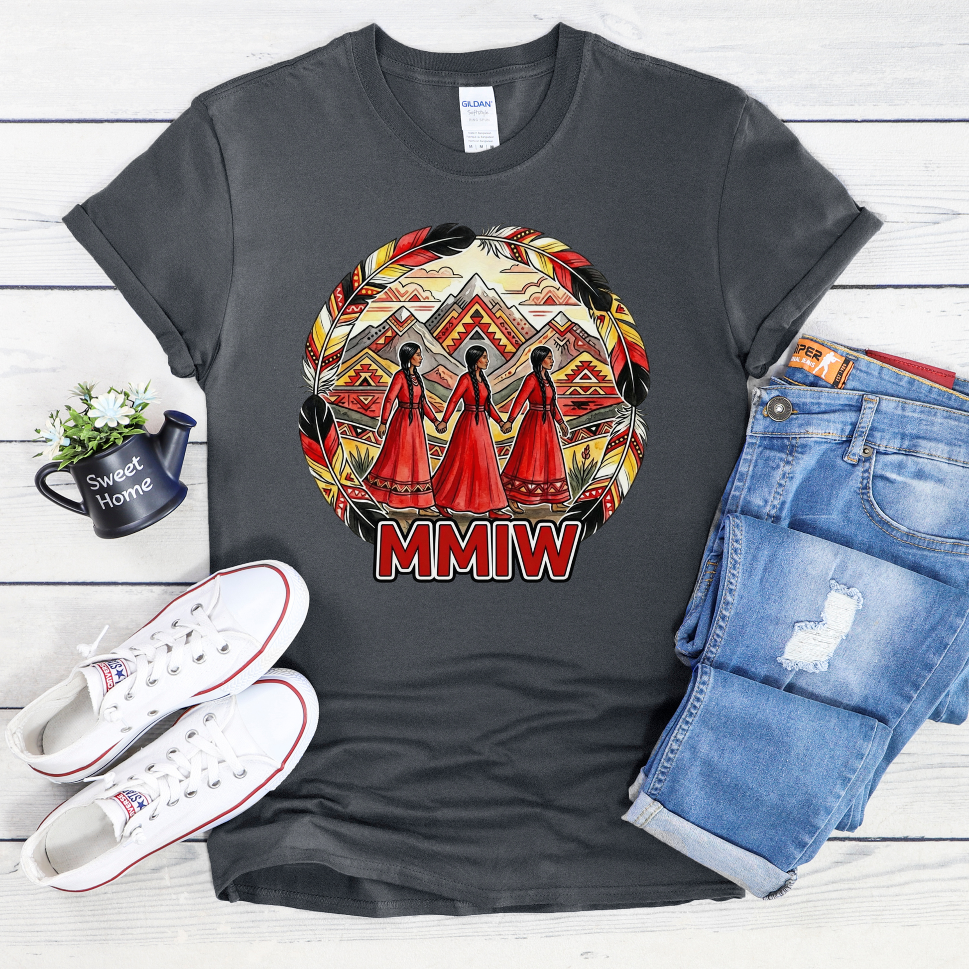 Gray t-shirt with a colorful design and 'MMIW' text, paired with white sneakers and blue jeans on a wooden surface. MMIW shirt, MMIW awareness, Indigenous t shirt, Missing and Murdered Indigenous Women, Indigenous graphic tee, Indigenous awareness shirt, unisex t shirt, activism shirt, Indigenous justice, Two Spirit awareness, Native apparel, awareness tee, Indigenous owned brand, feather frame shirt, statement t shirt