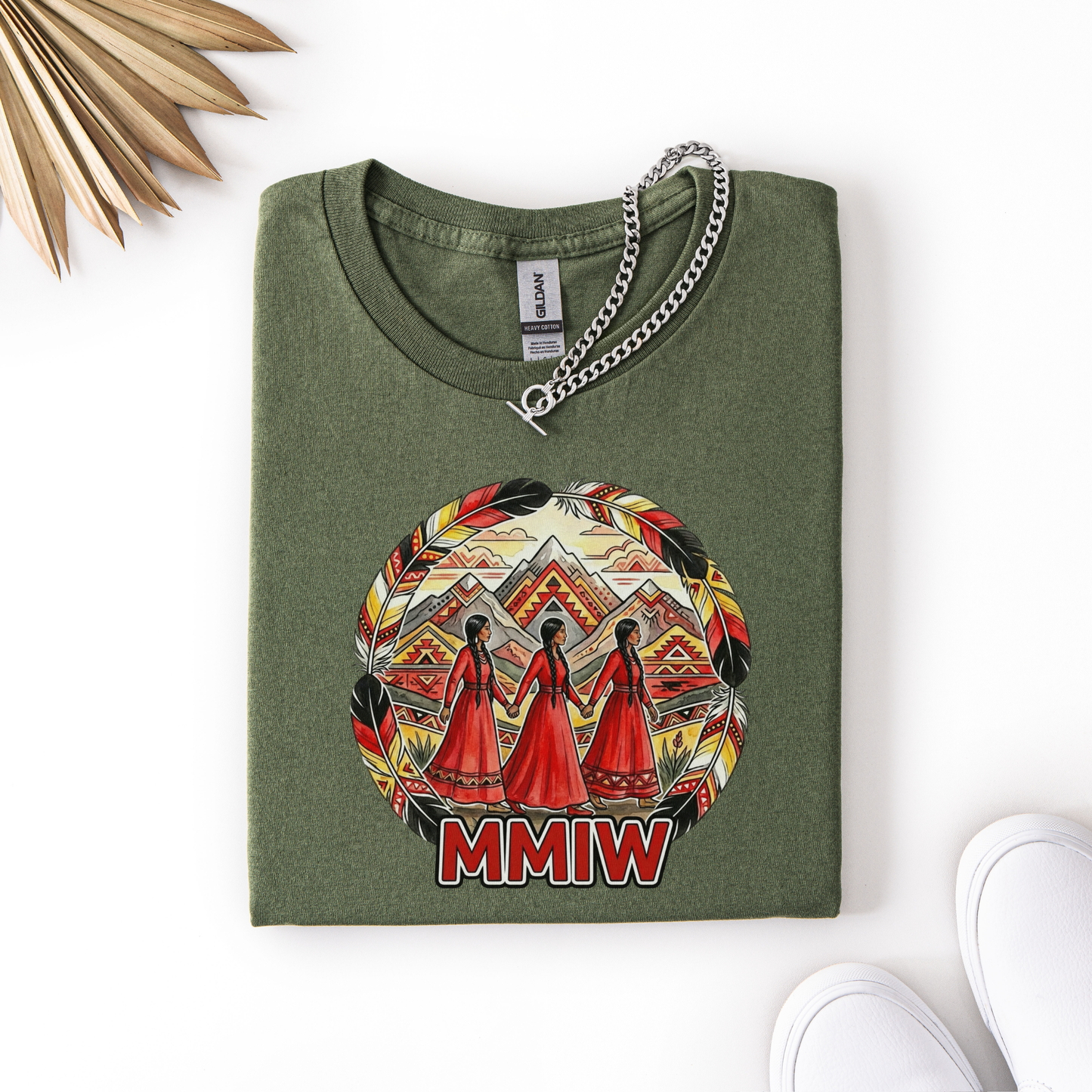 Folded green t-shirt with a colorful graphic design and 'MMIW' text on a white background. MMIW shirt, MMIW awareness, Indigenous t shirt, Missing and Murdered Indigenous Women, Indigenous graphic tee, Indigenous awareness shirt, unisex t shirt, activism shirt, Indigenous justice, Two Spirit awareness, Native apparel, awareness tee, Indigenous owned brand, feather frame shirt, statement t shirt
