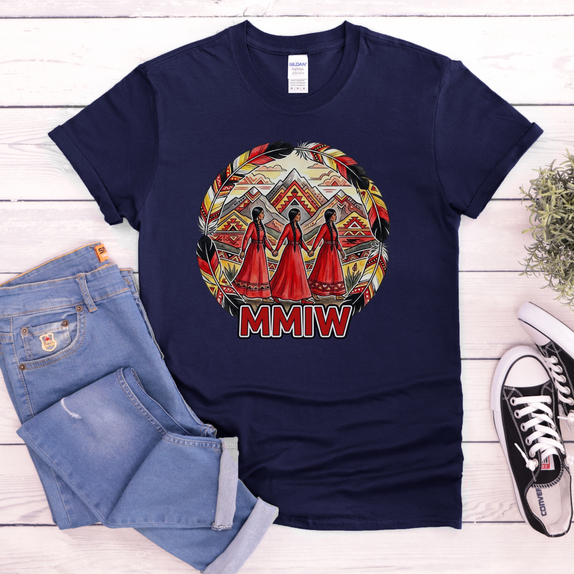 Navy blue t-shirt with a colorful design and 'MMIW' text, paired with jeans and sneakers on a wooden surface. MMIW shirt, MMIW awareness, Indigenous t shirt, Missing and Murdered Indigenous Women, Indigenous graphic tee, Indigenous awareness shirt, unisex t shirt, activism shirt, Indigenous justice, Two Spirit awareness, Native apparel, awareness tee, Indigenous owned brand, feather frame shirt, statement t shirt