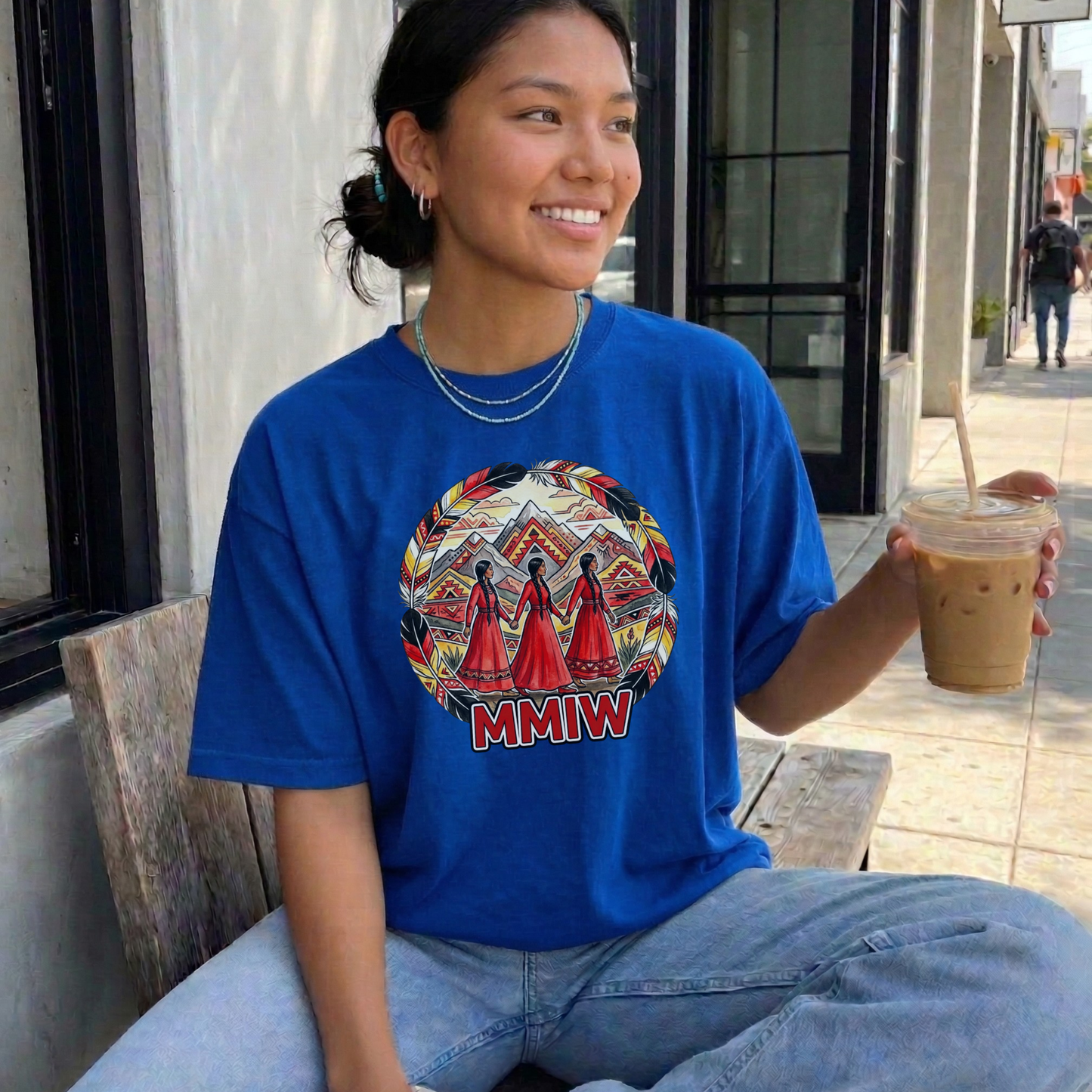Woman wearing a blue t-shirt with a graphic design and text, holding a drink outdoors. MMIW shirt, MMIW awareness, Indigenous t shirt, Missing and Murdered Indigenous Women, Indigenous graphic tee, Indigenous awareness shirt, unisex t shirt, activism shirt, Indigenous justice, Two Spirit awareness, Native apparel, awareness tee, Indigenous owned brand, feather frame shirt, statement t shirt