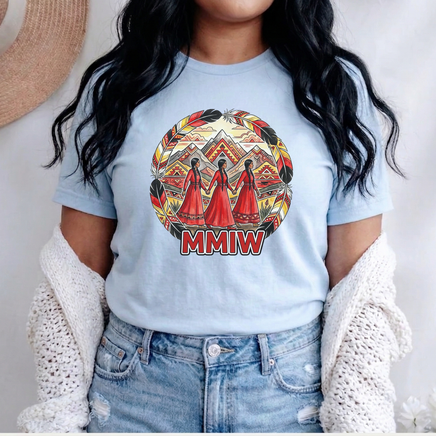 Person wearing a light blue t-shirt with a graphic design and 'MMIW' text, standing against a neutral background. MMIW shirt, MMIW awareness, Indigenous t shirt, Missing and Murdered Indigenous Women, Indigenous graphic tee, Indigenous awareness shirt, unisex t shirt, activism shirt, Indigenous justice, Two Spirit awareness, Native apparel, awareness tee, Indigenous owned brand, feather frame shirt, statement t shirt