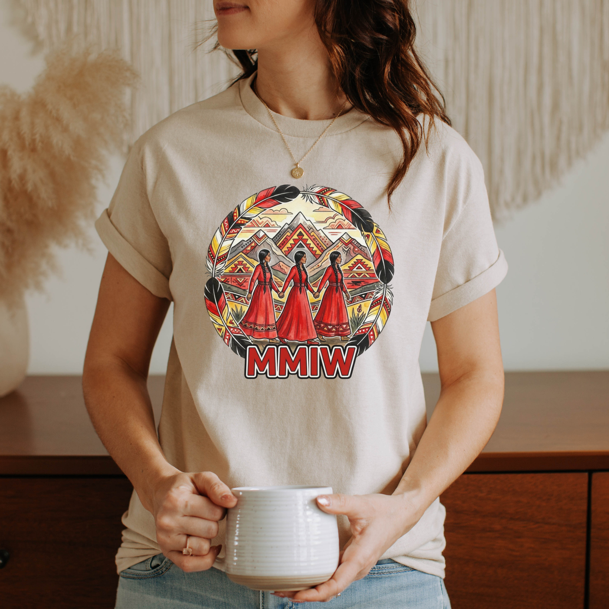 Person wearing a t-shirt with a design and 'MMIW' text, holding a mug. MMIW shirt, MMIW awareness, Indigenous t shirt, Missing and Murdered Indigenous Women, Indigenous graphic tee, Indigenous awareness shirt, unisex t shirt, activism shirt, Indigenous justice, Two Spirit awareness, Native apparel, awareness tee, Indigenous owned brand, feather frame shirt, statement t shirt