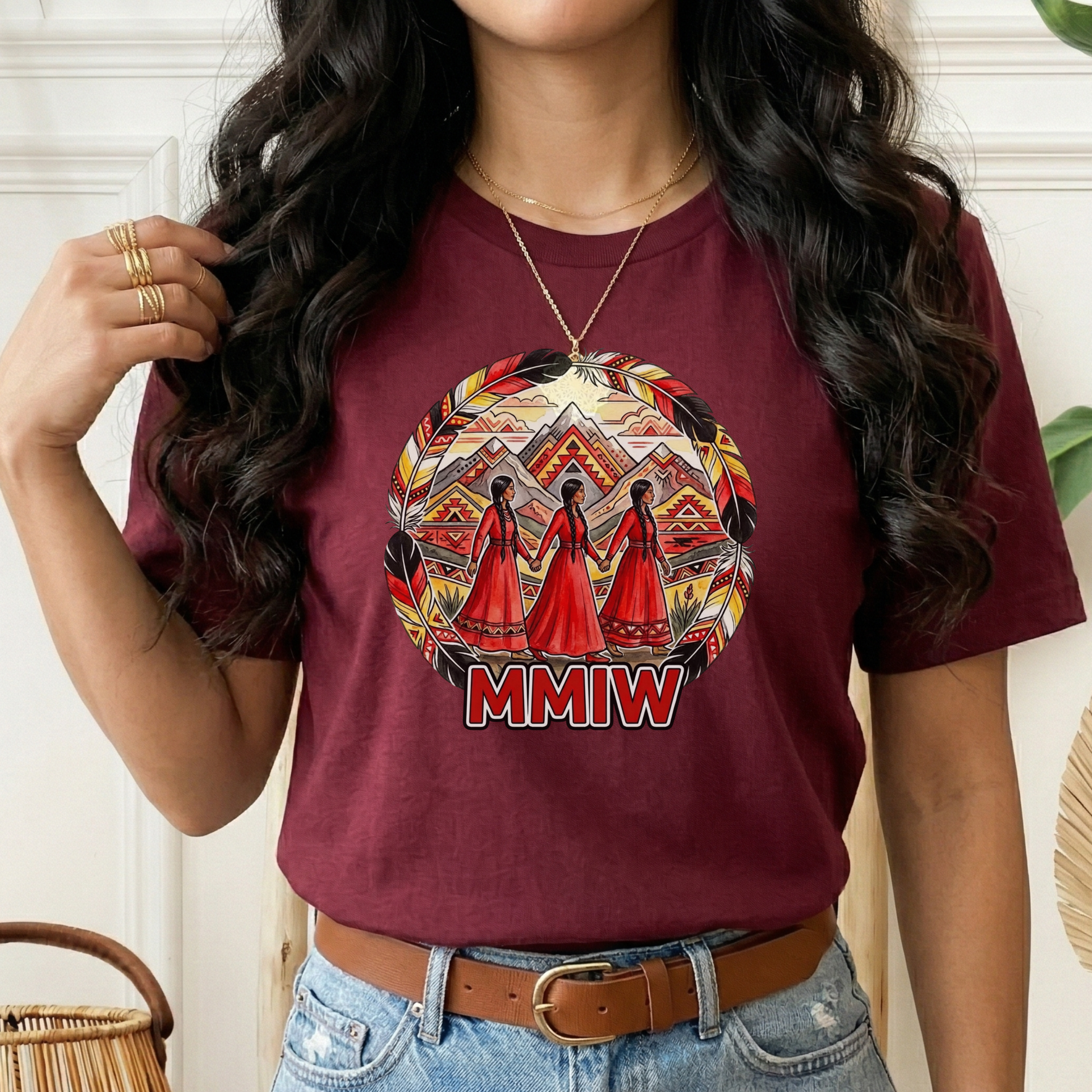Person wearing a maroon t-shirt with a graphic design and 'MMIW' text. MMIW shirt, MMIW awareness, Indigenous t shirt, Missing and Murdered Indigenous Women, Indigenous graphic tee, Indigenous awareness shirt, unisex t shirt, activism shirt, Indigenous justice, Two Spirit awareness, Native apparel, awareness tee, Indigenous owned brand, feather frame shirt, statement t shirt