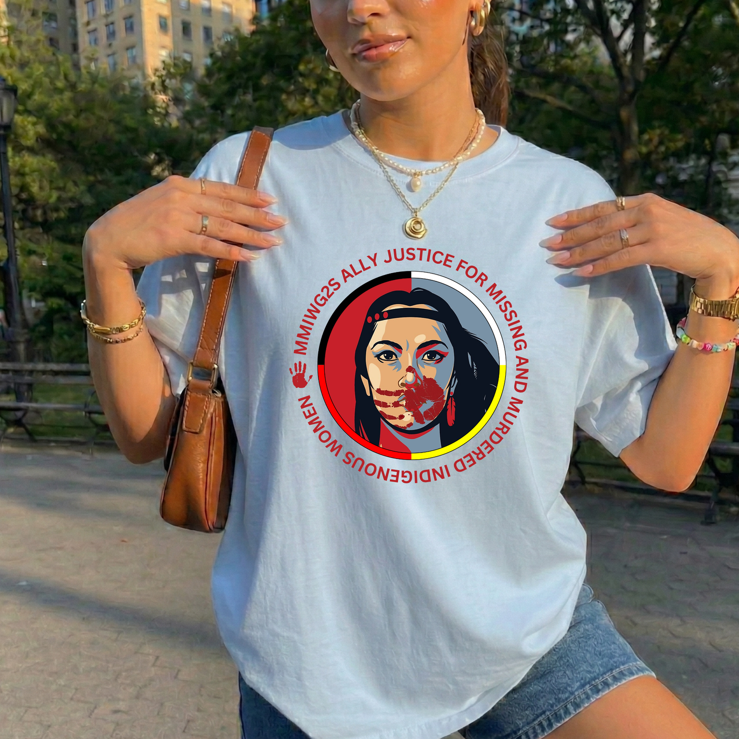 Person wearing a white t-shirt with a graphic design and text, standing outdoors. MMIWG2S shirt, Missing Murdered Indigenous Women tee, Indigenous ally shirt, MMIWG awareness apparel, justice for Indigenous women clothing, truth and reconciliation tee, National Day for Truth shirt, Indigenous activism clothing, 2SLGBTQQIA ally shirt, Canada missing women awareness, social justice tee, rally shirt Indigenous rights, solidarity shirt, awareness apparel Indigenous, activism t-shirt